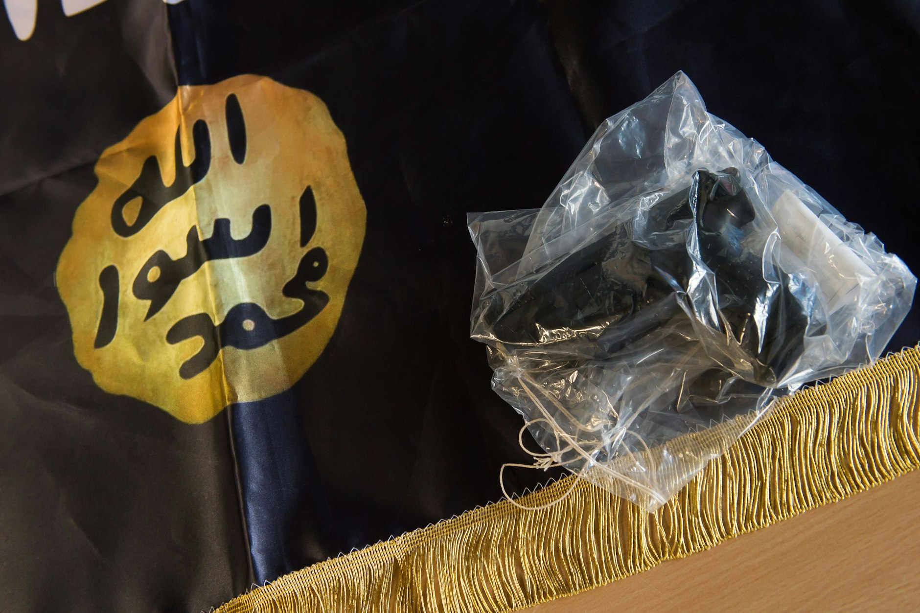 Eine beschlagnahmte Waffe liegt während einer Pressekonferenz der Polizei auf einer IS-Flagge.&nbsp;