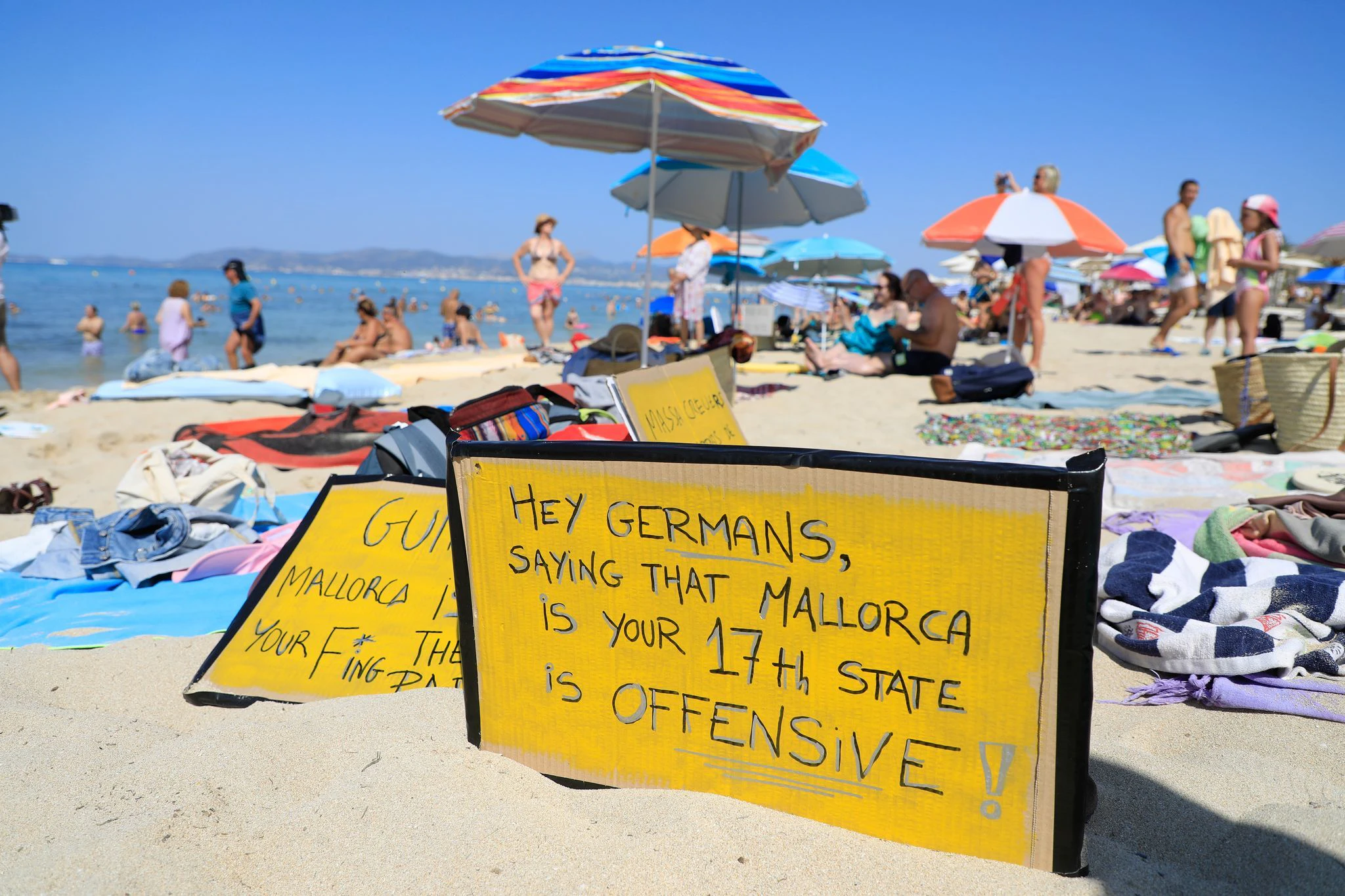 „Hallo Deutsche, zu sagen, dass Mallorca euer 17. Bundesland sei, ist beleidigend“, steht auf einem Schild am Ballermann.