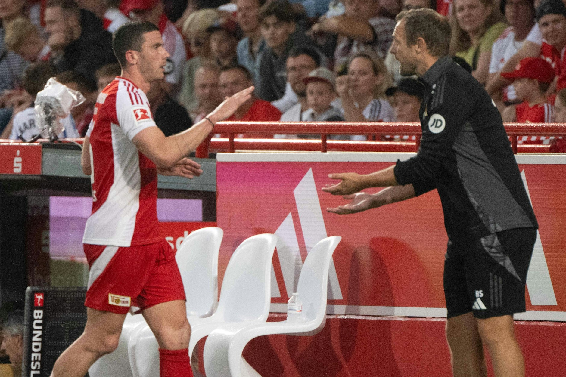 Robin Gosens und Trainer Bo Svensson klatschen beim Spiel des 1. FC Union gegen Real San Seastian ab.