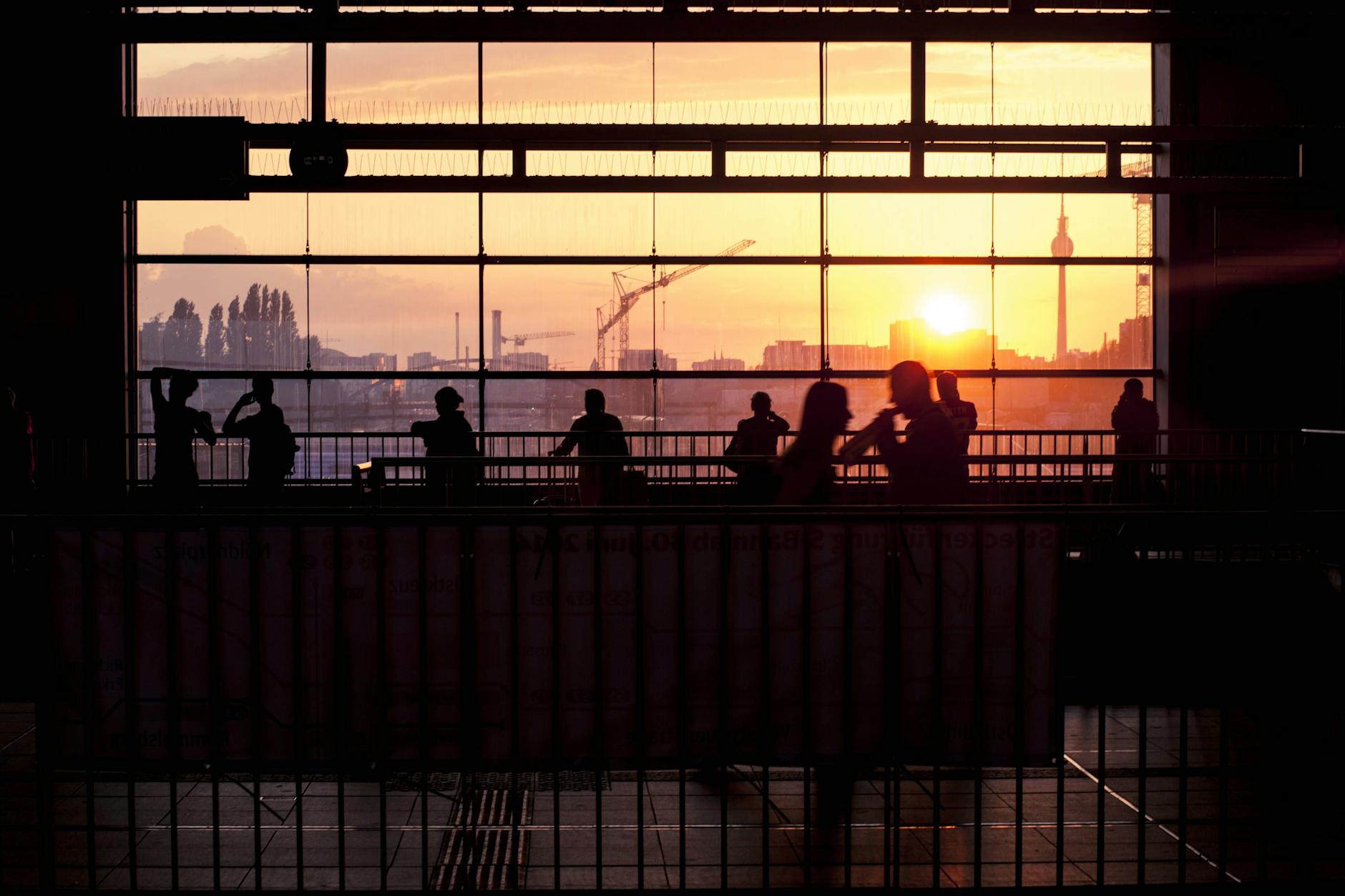 Menschen warten am Bahnhof Ostkreuz in Berlin auf die Bahn. 