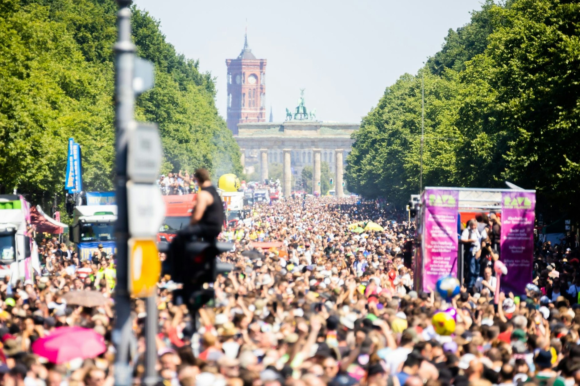Menschen feiern bei der Technoparade „Rave the Planet“ auf der Straße des 17. Juni vor dem Brandenburger Tor. 