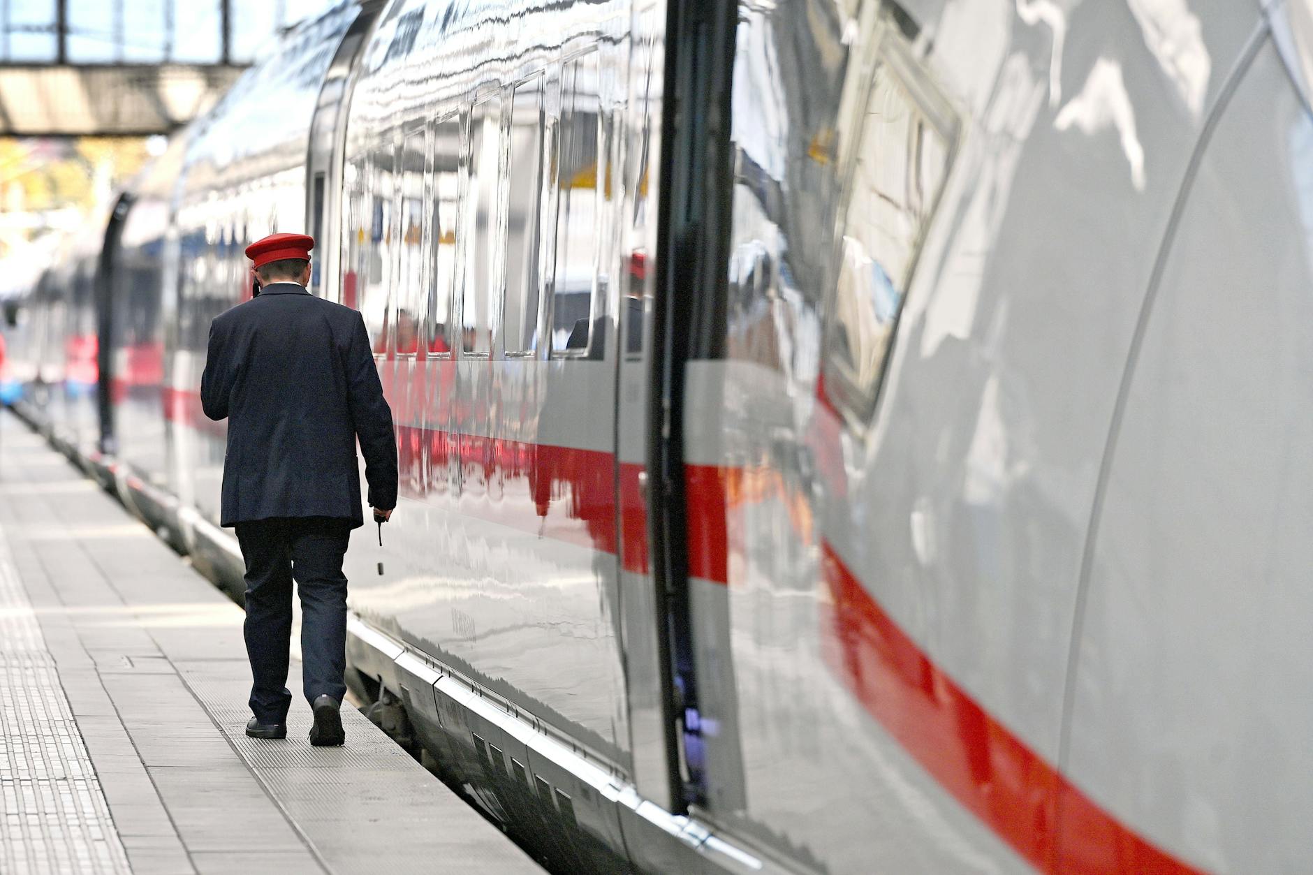 Startklar für die Reise: ein Zugbegleiter der Deutschen Bahn und ein Intercity-Express (ICE)