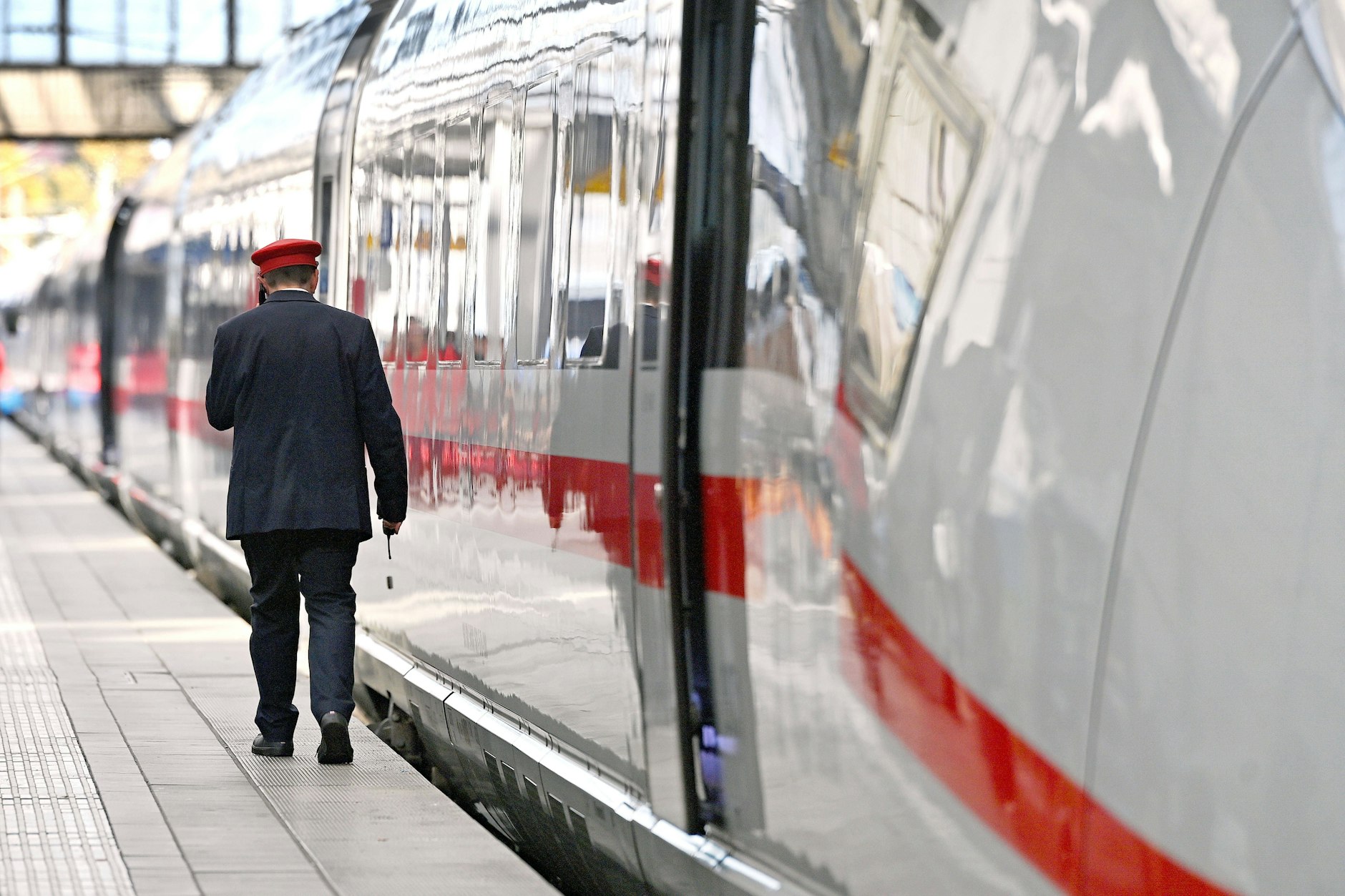 Startklar für die Reise: ein Zugbegleiter der Deutschen Bahn und ein Intercity-Express (ICE)