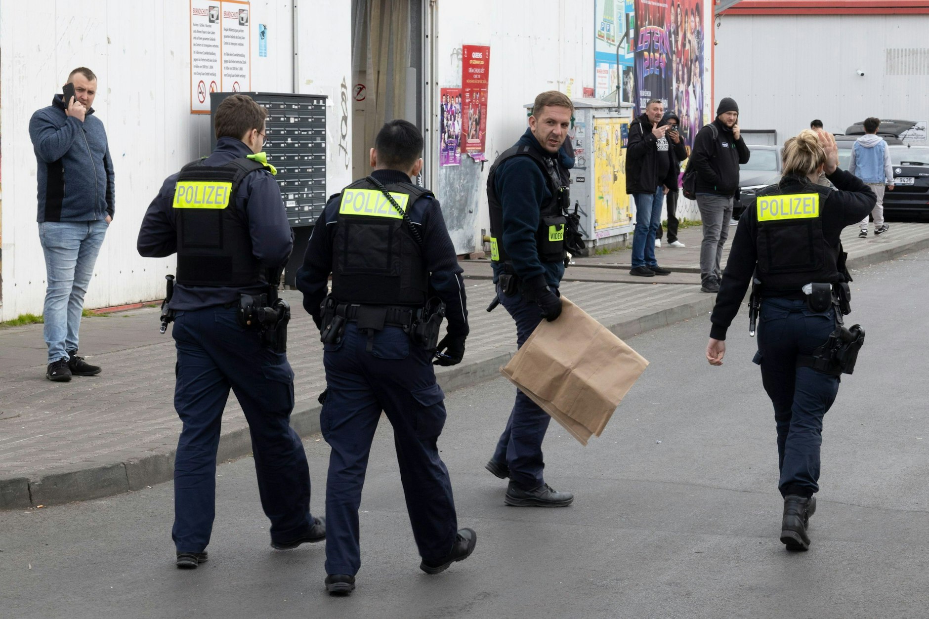 Berliner Polizisten auf dem Gelände des Dong Xuan Centers: In der braunen Papiertüte befindet sich ein sichergestelltes Messer, das in der Schlägerei vom 15. März eingesetzt wurde.