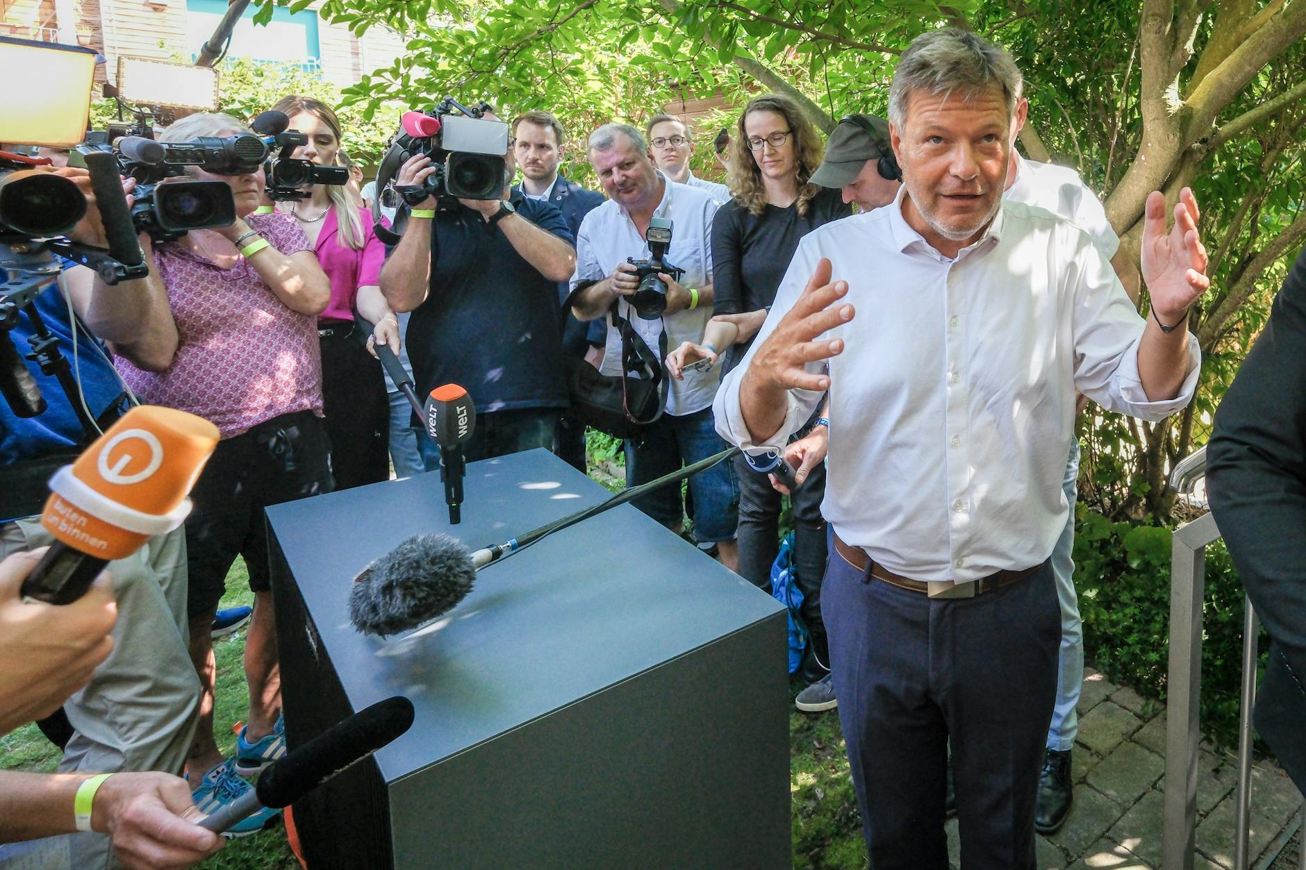 Bundeswirtschaftsminister Robert Habeck (Grüne, r.) steht bei einem Besuch in Bremen im Garten eines Privathauses neben einer Wärmepumpe, die eingebaut werden soll. Er muss das Image der klimafreundlichen Wärmetechnologie verbessern.