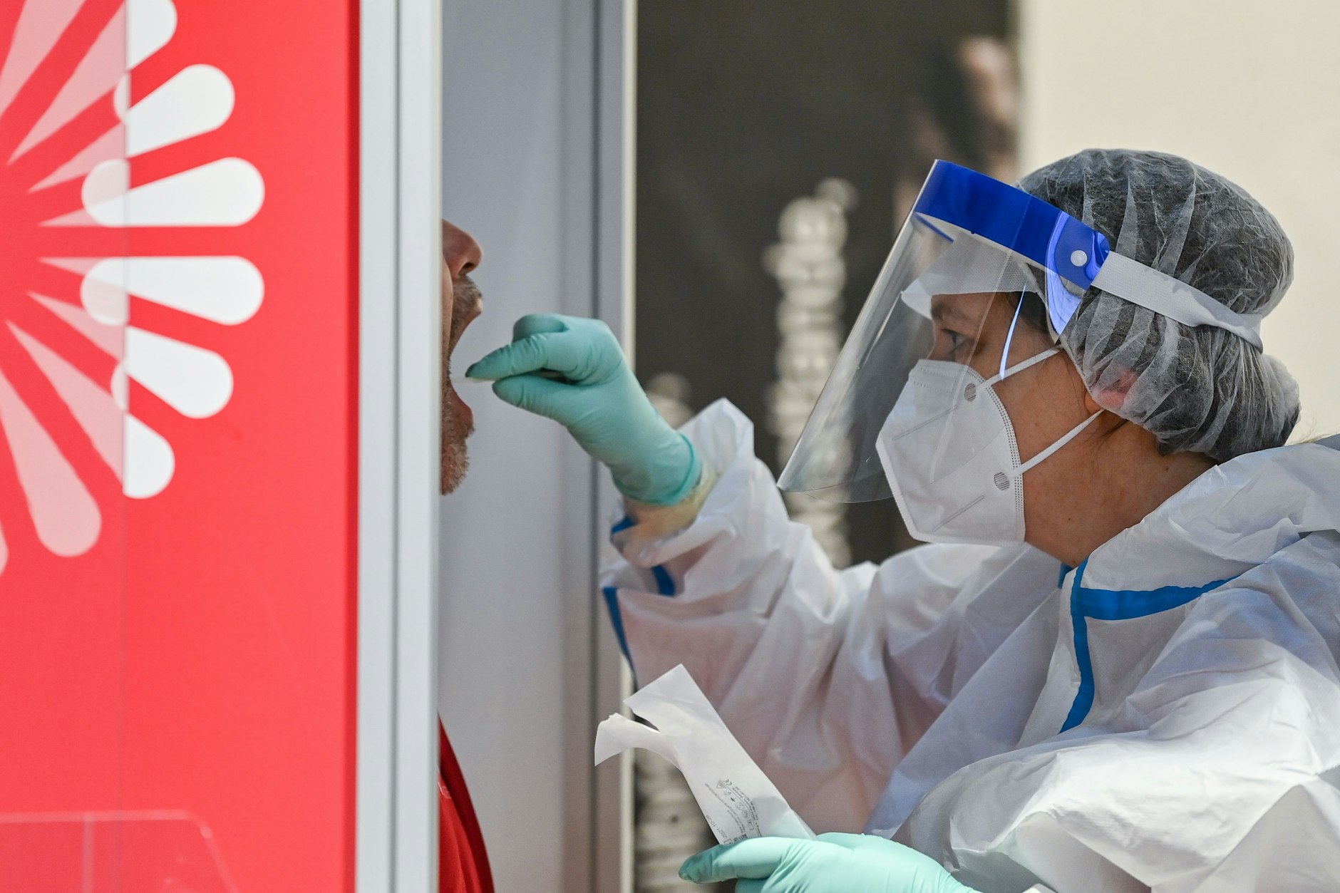 05.11.2020: Eine Mitarbeiterin im weißen Schutzanzug nimmt im privaten Covid-19-Testzentrum im BER eine Probe.