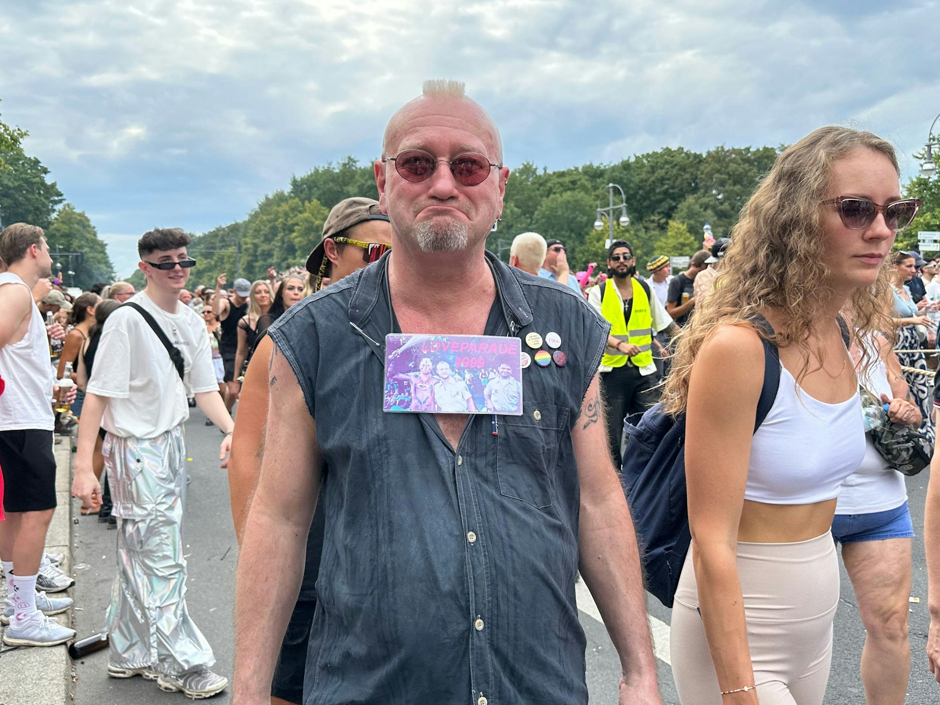 Dieser Mann war schon 1999 auf der Loveparade, wie das Foto um seinen Hals beweist. Die erste Loveparade fand am 1. Juli 1989 statt.