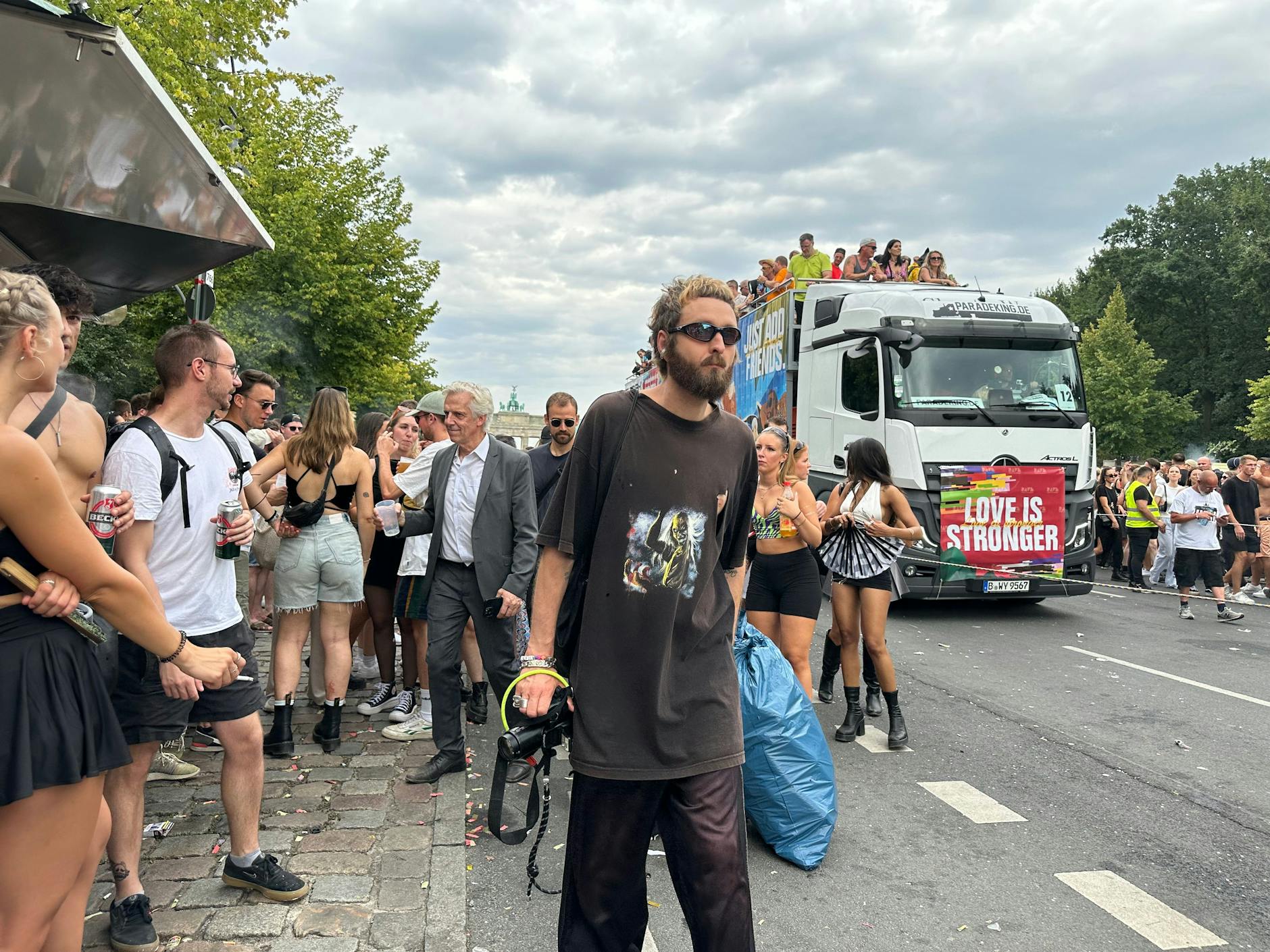 Zwei Zweiteiler: Vorn der Fotograf in dunkelbraunem T-Shirt und Jeans, hinten der Mann im grauen Anzug, der etwas exotisch auf der Parade wirkte.