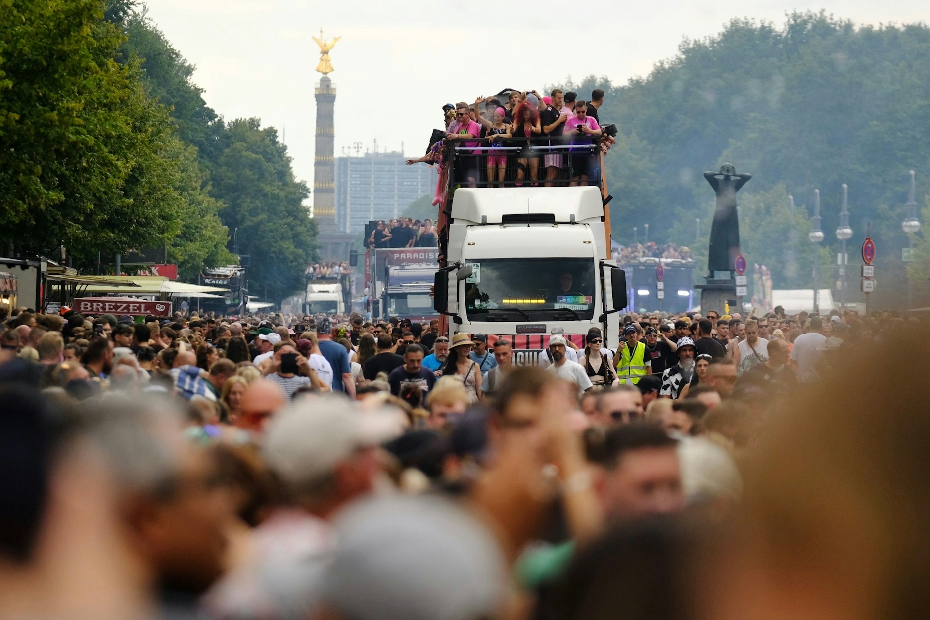 Paradewagen fahren umringt von tanzenden Ravern durch Berlin.