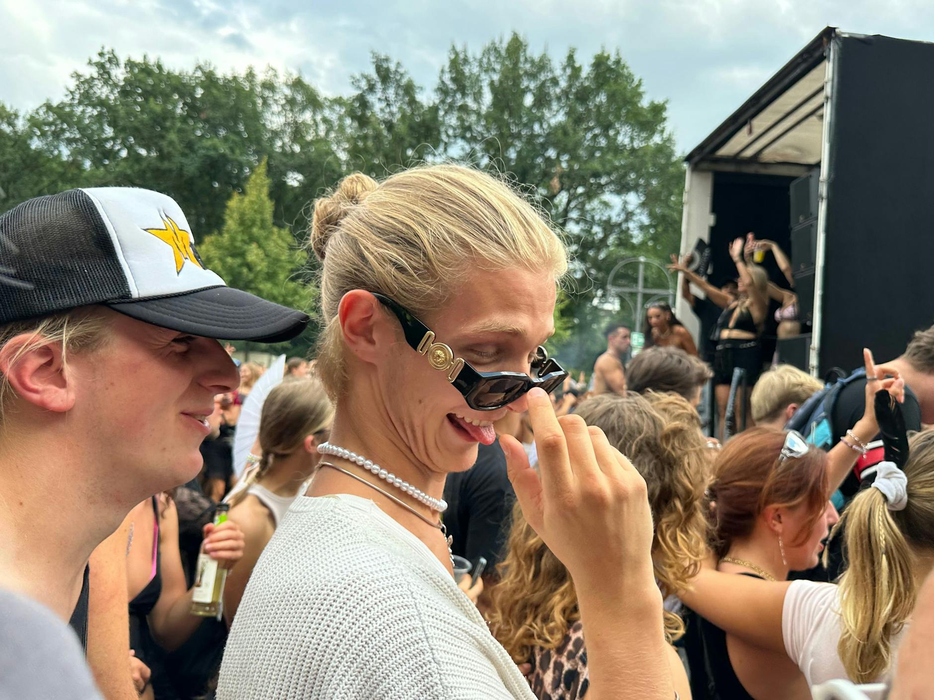 Blondes Haar, Perlenschmuck und Versace-Brille – fertig ist der poshe Raver.