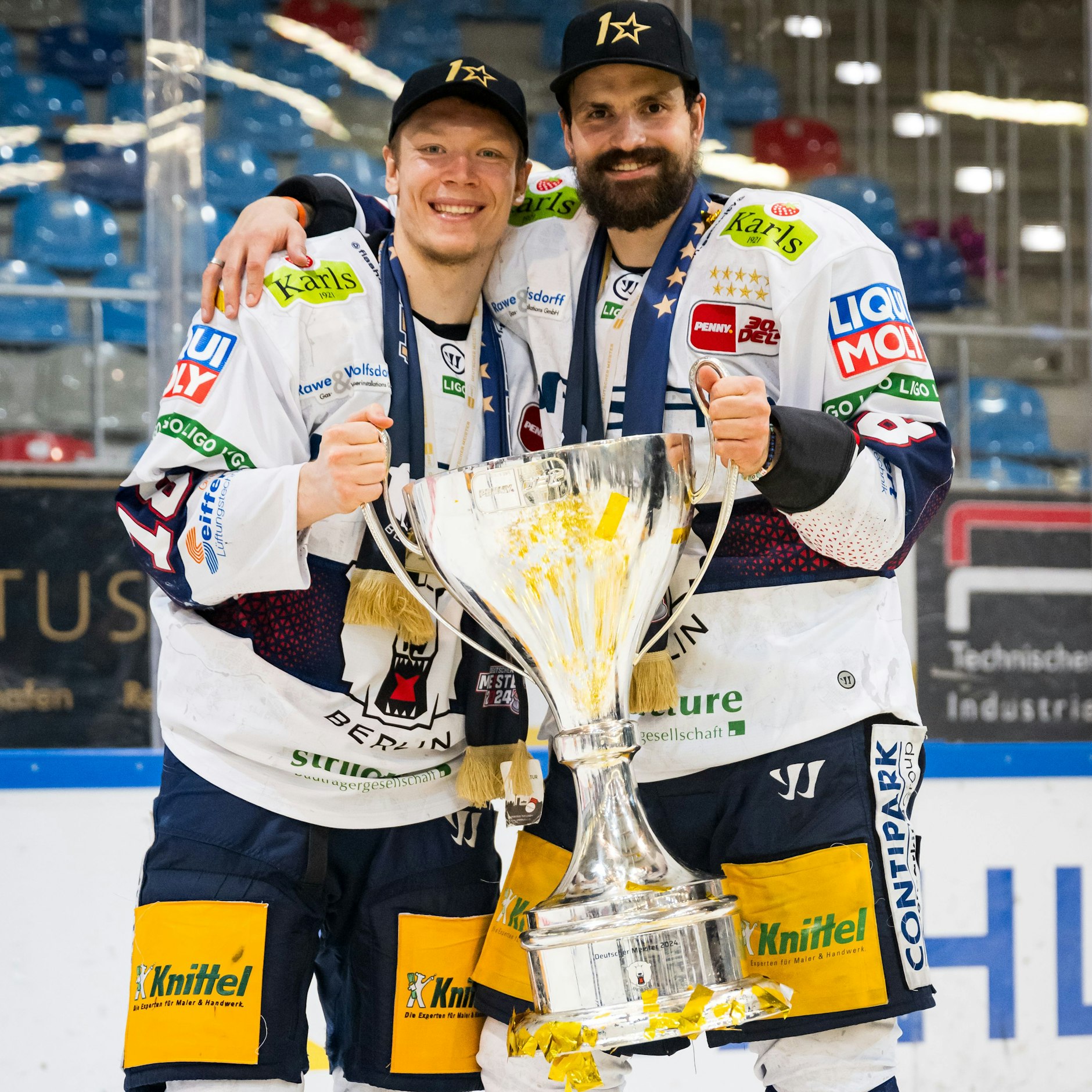 Nach der Finalserie gegen Bremerhaven hält Marco Nowak (r.) erstmals den Meisterpokal in seinen Händen. Jonas Müller packt mit zu.