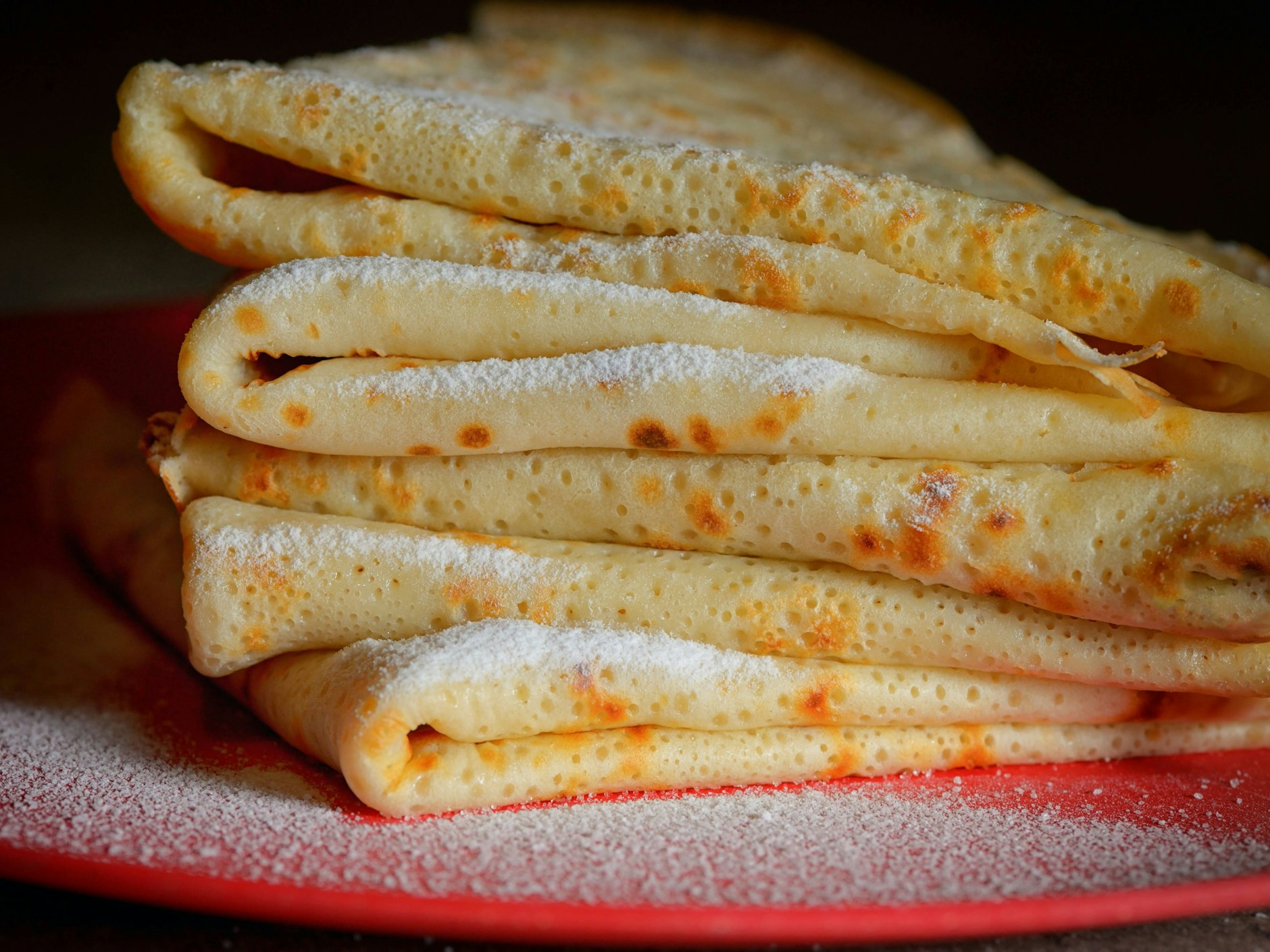 Die fertigen Buttermilchplinsen können Sie auch mit Puderzucker servieren – zu dem Rezept passen die unterschiedlichsten Beilagen.