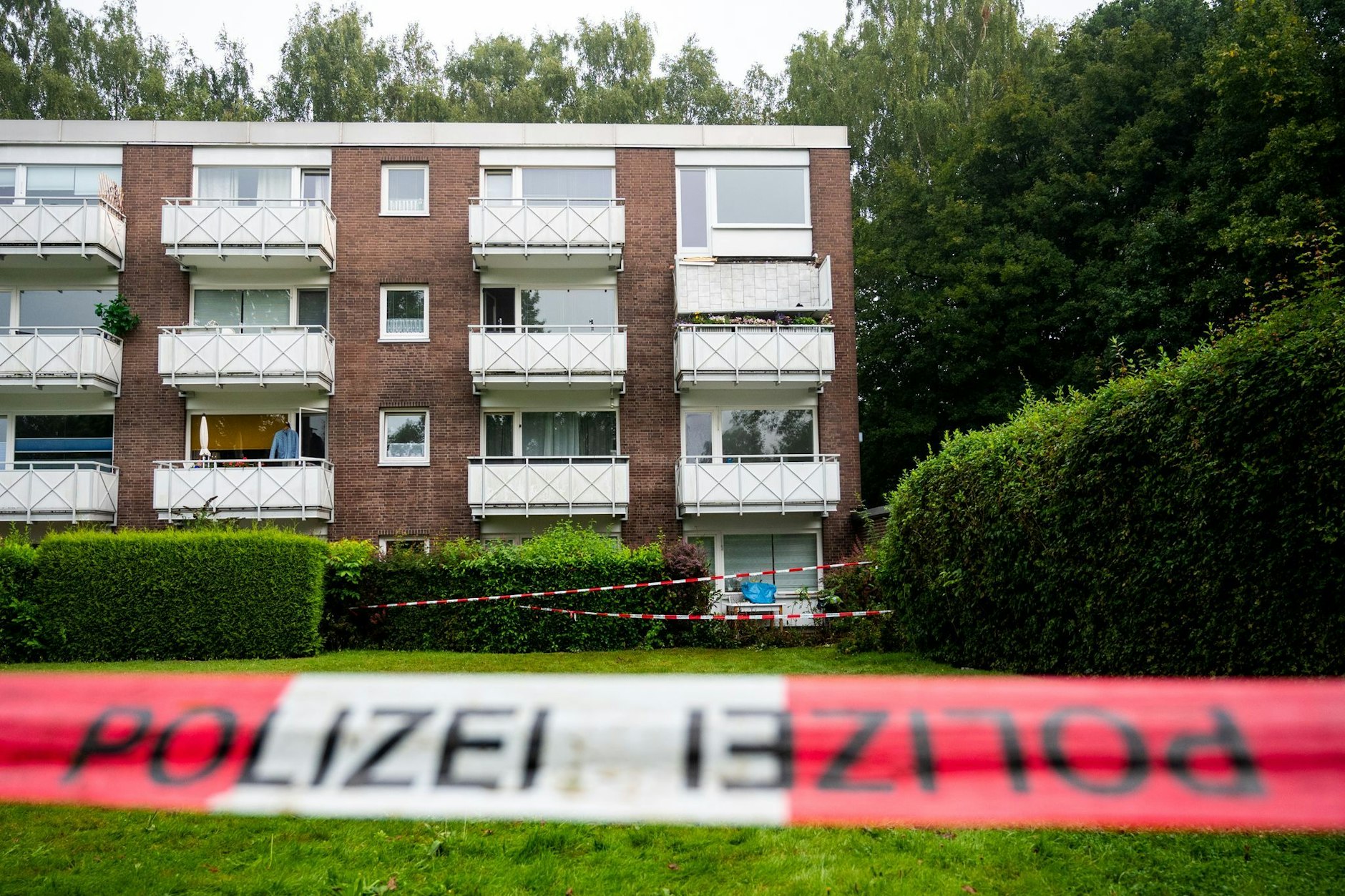 Absperrband der Polizei hängt im Stadtteil Langenhorn vor einem Mehrfamilienhaus. Bei dem Absturz eines Balkons wurden sechs Menschen verletzt. Einer starb. 