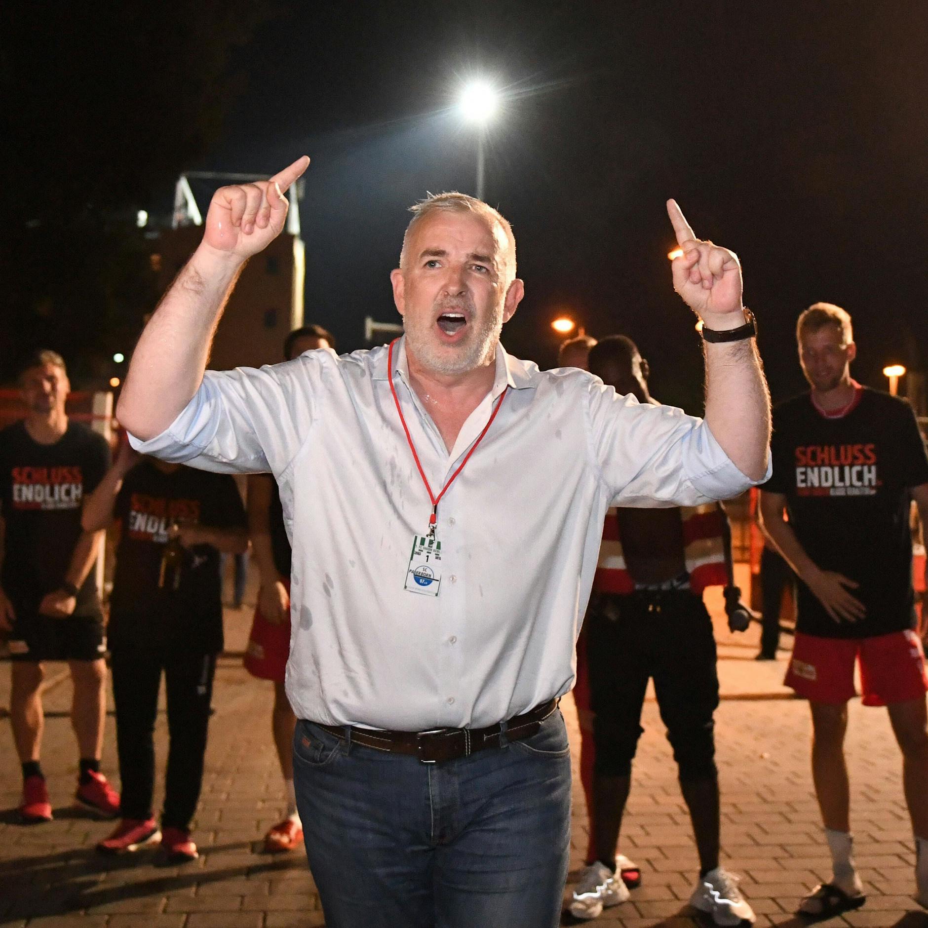 Dirk Zingler feiert nach dem 32. Spieltag der Saison 2019/20 mit der Mannschaft im Hintergrund den Klassenerhalt des 1. FC Union.