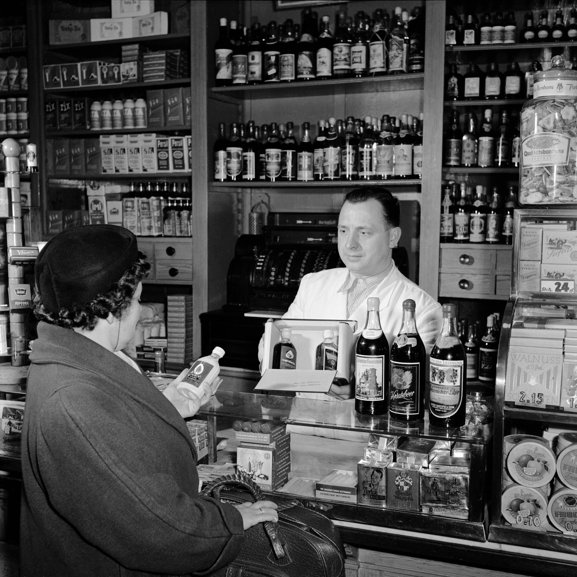 Schnaps in der DDR: Eine Kundin kauft in einem Spirituosen-Laden in Merseburg eine Flasche Eierlikör.