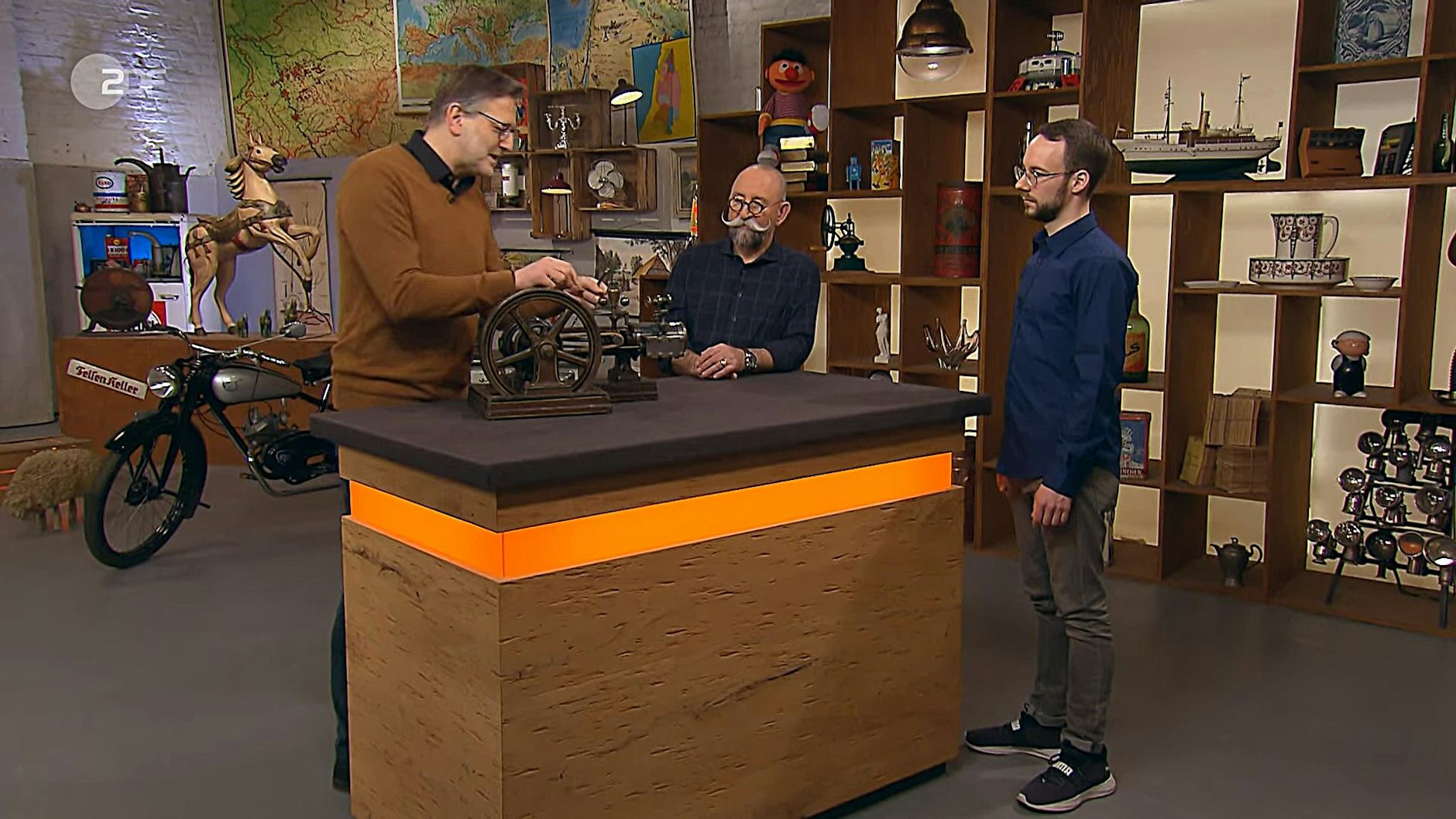 Student Daniel Hoff mit Moderator Horst Lichter und Experte Detlev Kümmel bei der Expertise bei Bares für Rares.