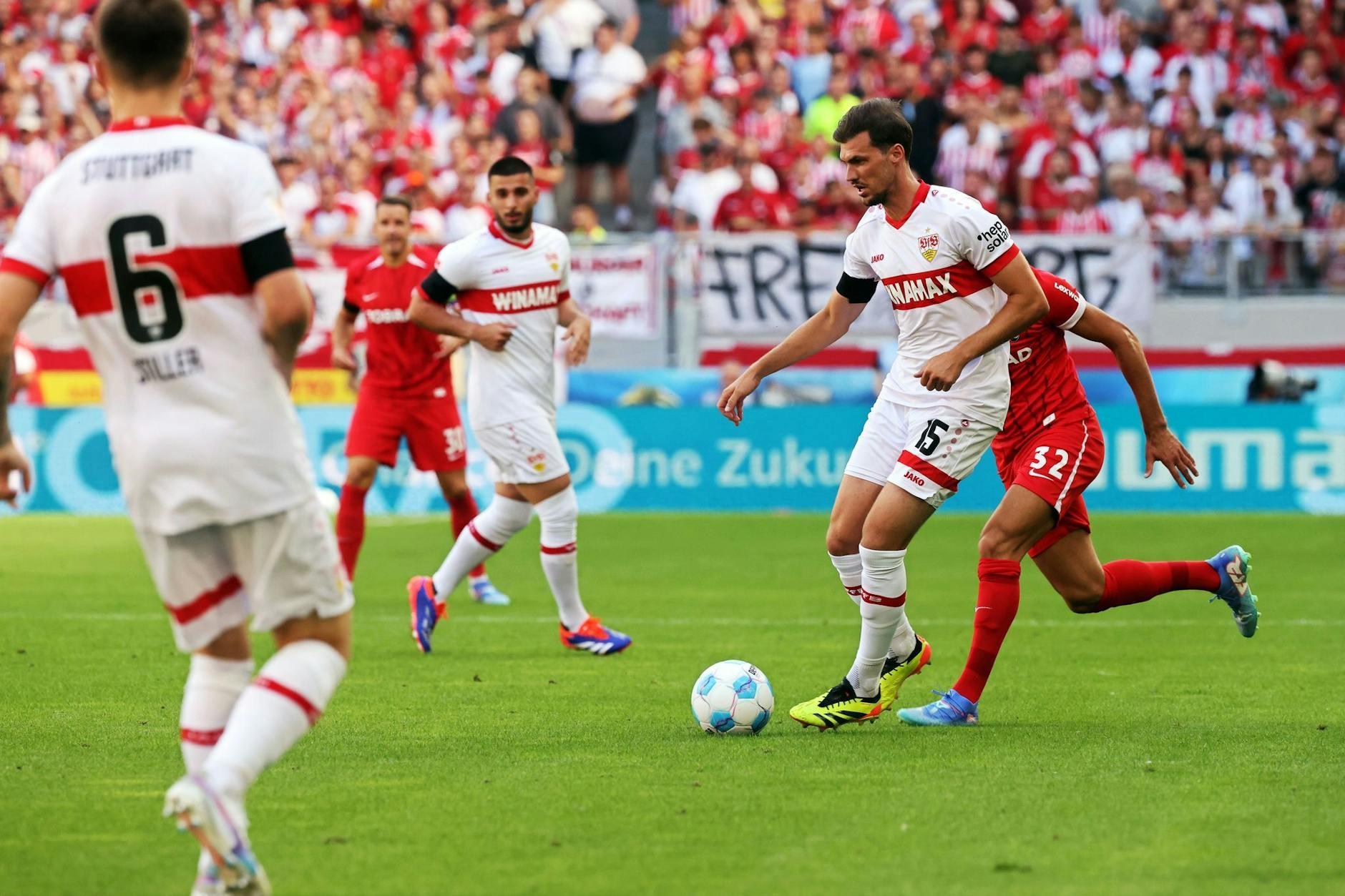 Stuttgarts Pascal Stenzel (Zweiter von rechts) und Freiburgs Vincenzo Grifo (rechts) kämpfen um den Ball.