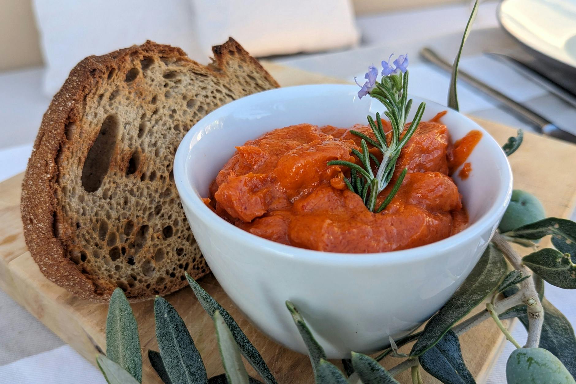 Für die Tomatenbutter benötigt man weiche Butter und vier weitere Zutaten. Das Vermischen geht so schnell, dass man das auch noch schafft, wenn die Gäste schon da sind.