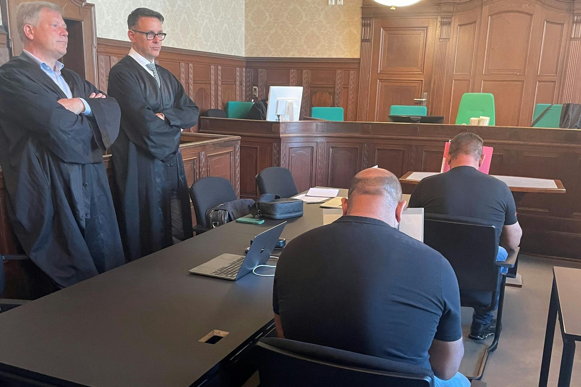 Vater Constantin L. (52, rechts vorn) und Sohn Constantin-Ionut L. (34) vor Gericht. Die Rumänen sollen Landsleute auf Baustellen in Berlin ausgebeutet haben.