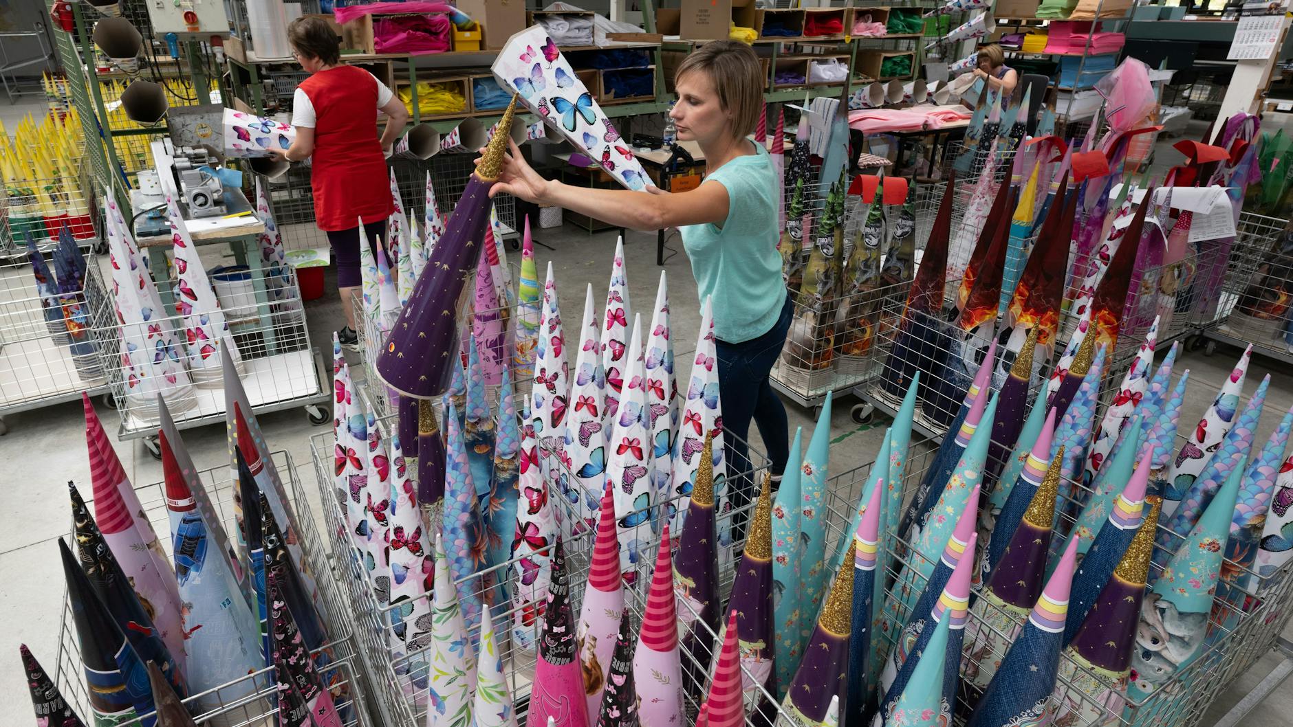 Bettina Nestler (vorn) von „Nestler Feinkartonagen“ in Ehrenfriedersdorf schaut sich Zuckertüten der aktuellen Produktion an.