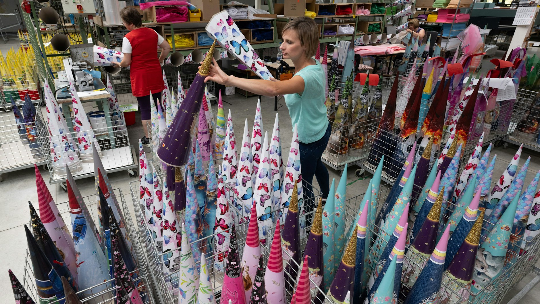Bettina Nestler (vorn) von „Nestler Feinkartonagen“ in Ehrenfriedersdorf schaut sich Zuckertüten der aktuellen Produktion an.