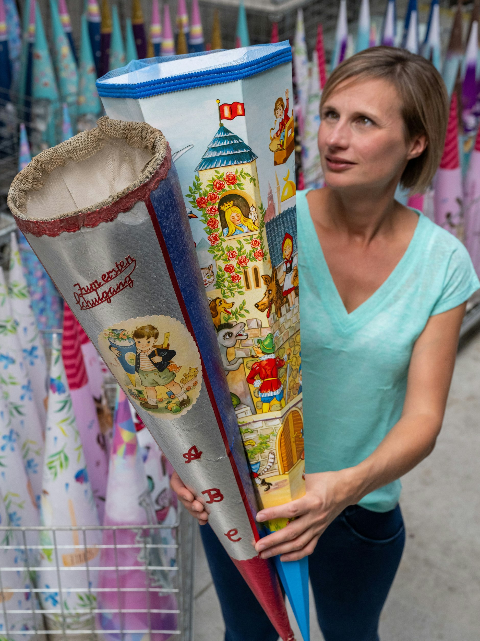 Firmenchefin Bettina Nestler zeigt Zuckertüten aus den 1960er Jahren (links) und ein Exemplar aus der späten DDR-Zeit.