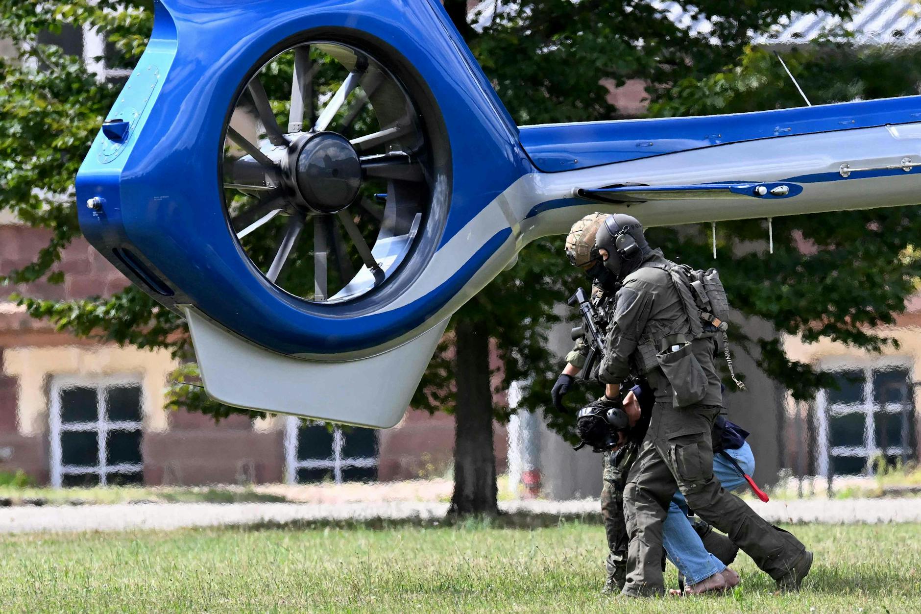 Angehörige einer Spezialeinheit der Polizei eskortieren einen Mann, der verdächtigt wird, für die Solinger Messerattacke verantwortlich zu sein.