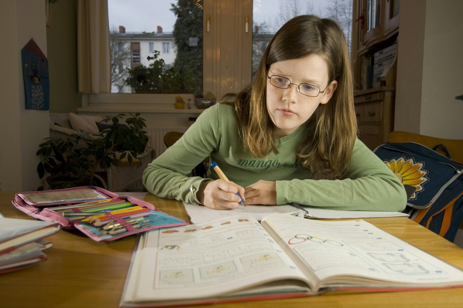 Ein Mädchen vor seinem Schreibheft. Für Schulmaterialien muss immer mehr ausgegeben werden.