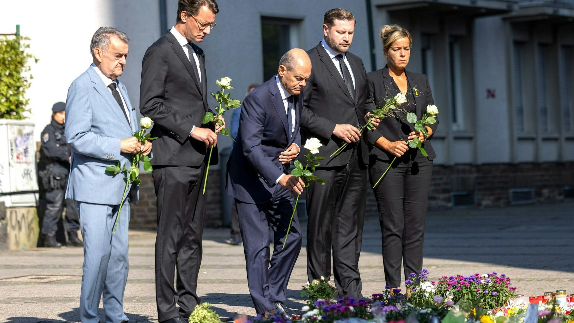 Bei der Messerattacke in Solingen hatte es drei Todesopfer und acht Verletzte gegeben. Bundeskanzler Olaf Scholz (M., SPD) und andere Politiker legen Blumen an einer Kirche in der Nähe des Tatorts ab. 