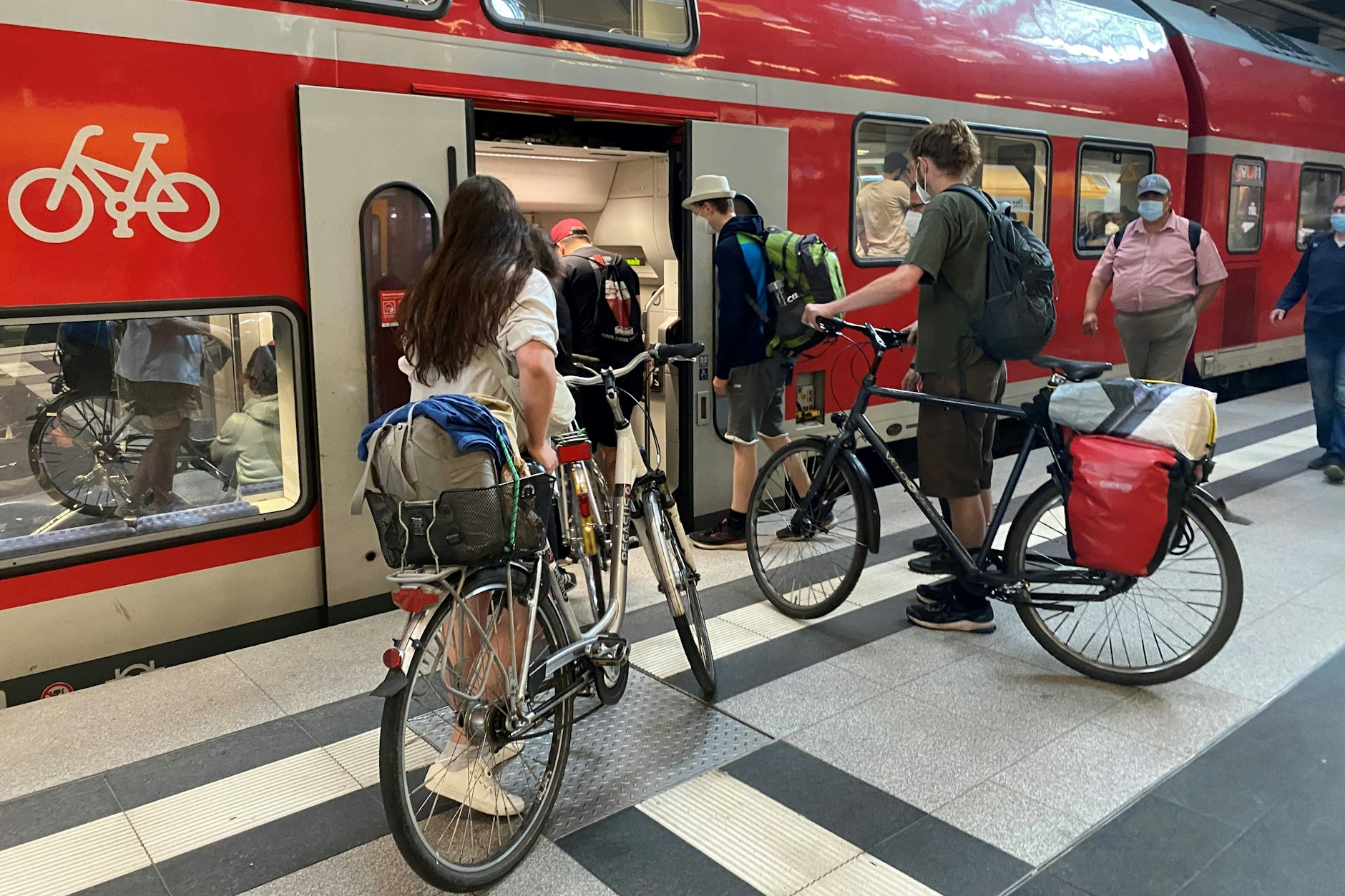Ist noch Platz für mich und mein Fahrrad? Fahrgäste drängen sich im Berliner Hauptbahnhof vor einem Regionalexpresszug der Deutschen Bahn der Linie RE5 in Richtung Ostsee.