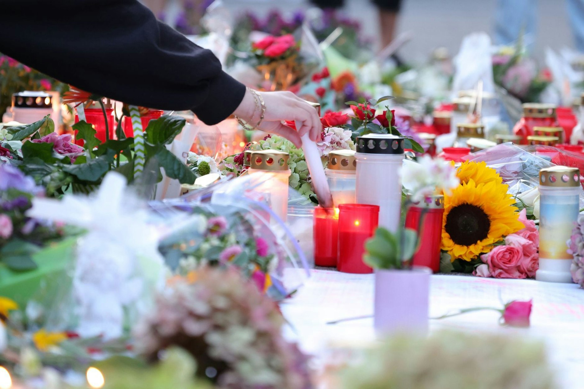 Nach der Messerattacke auf dem Solinger Stadtfest legen Menschen in der Nähe des Tatortes Blumen nieder und und zünden Kerzen zum Gedenken der Opfer an.&nbsp;