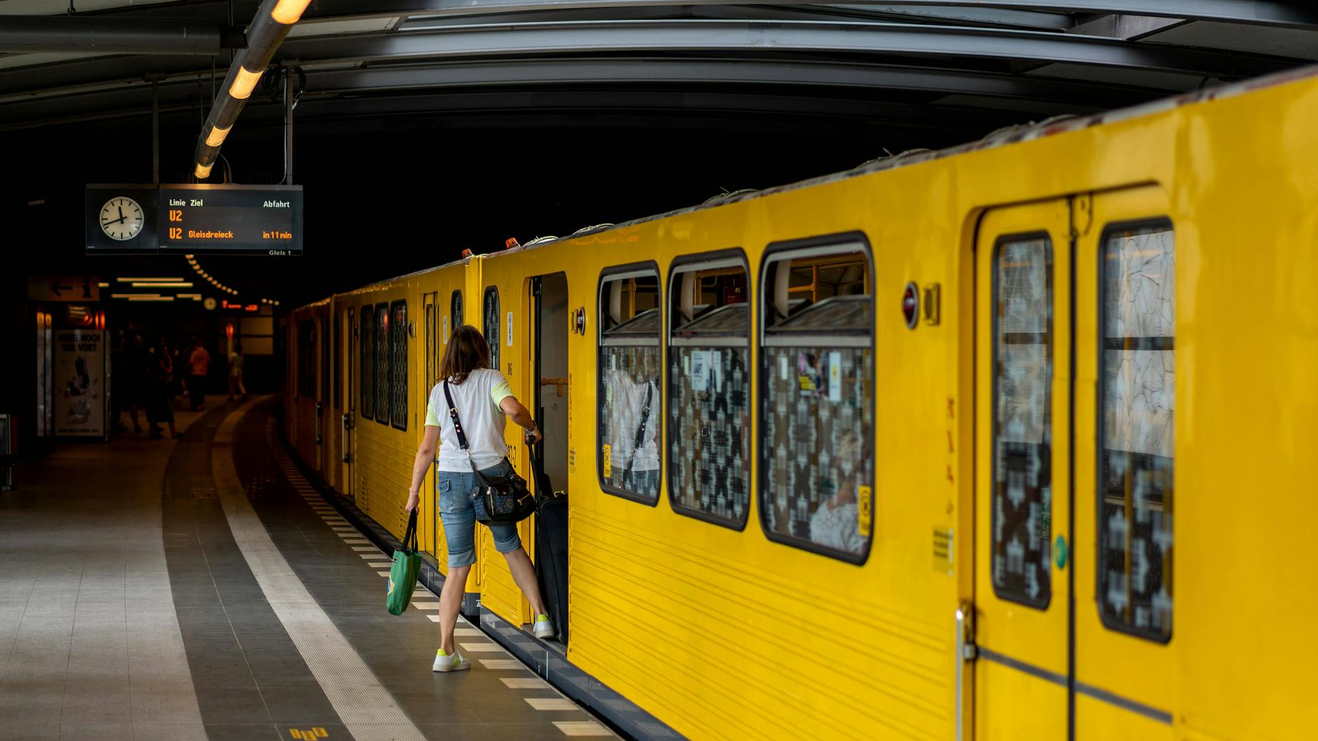 Eine Frau steigt bei Hitze in die U-Bahn der BVG. Die Fenster sind weit geöffnet.