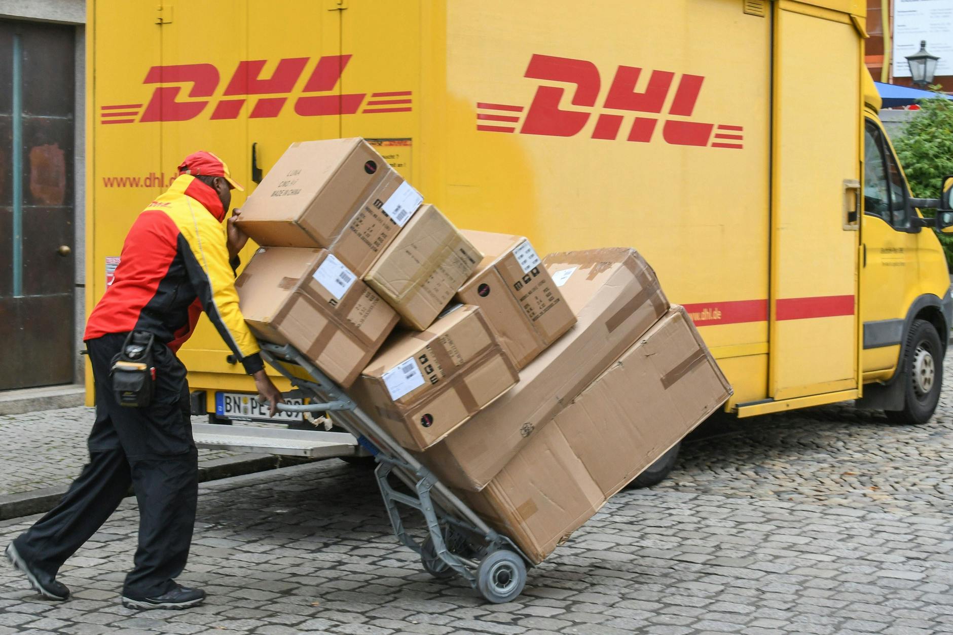 Ein DHL-Bote stellt Pakete zu (Symbolfoto). Die Sicherheitsbehörden warnen momentan vor Brandsätzen per Post.