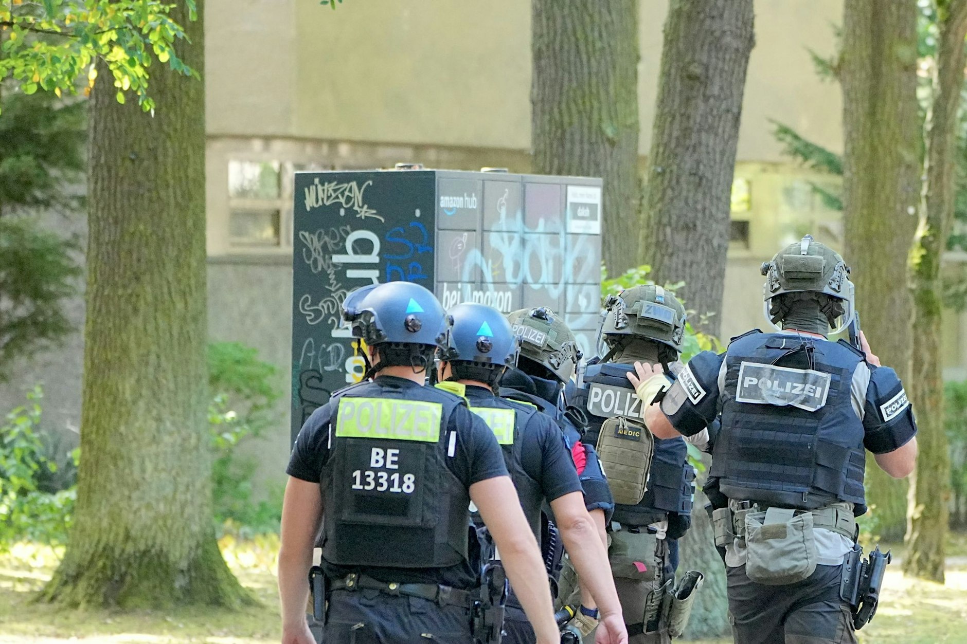 Hier rücken Polizisten eines Spezialeinsatzkommandos (SEK) mit gezogenen Waffen auf das Mehrfamilienhaus in Berlin-Nikolassee vor.