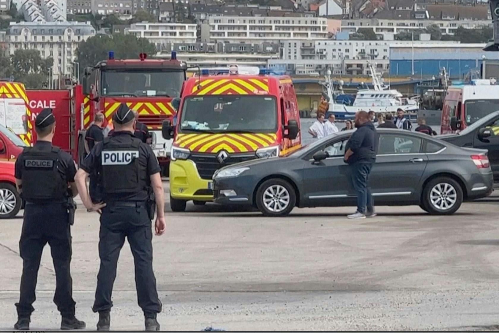 Polizisten und Rettungskräfte stehen im Hafen von Boulogne-Sur-Mer.