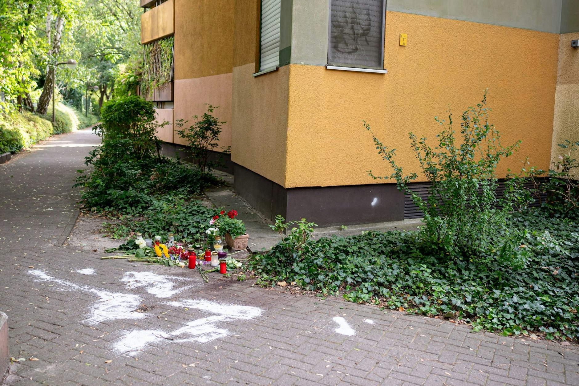 Kerzen und Blumen liegen in Zehlendorf an dem Ort, an dem ein Mann seine Ex-Frau erstochen haben soll. Die 36-jährige Mutter von vier Kindern war auf der Straße mit einem Messer getötet worden. 