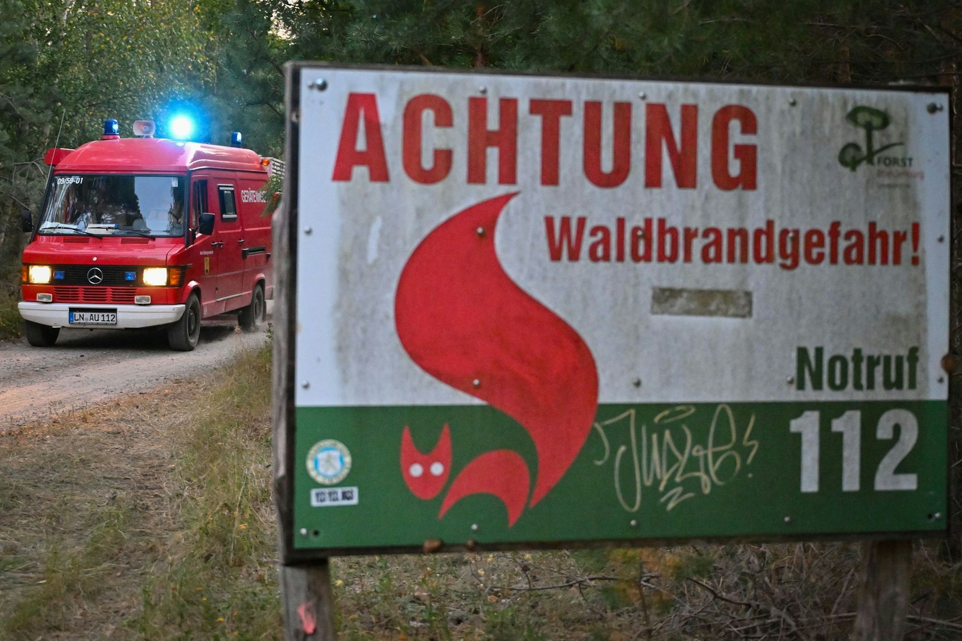 Ein Einsatzfahrzeug der Freiwilligen Feuerwehr vom Amt Unterspreewald kommt aus einem Wald gefahren.
