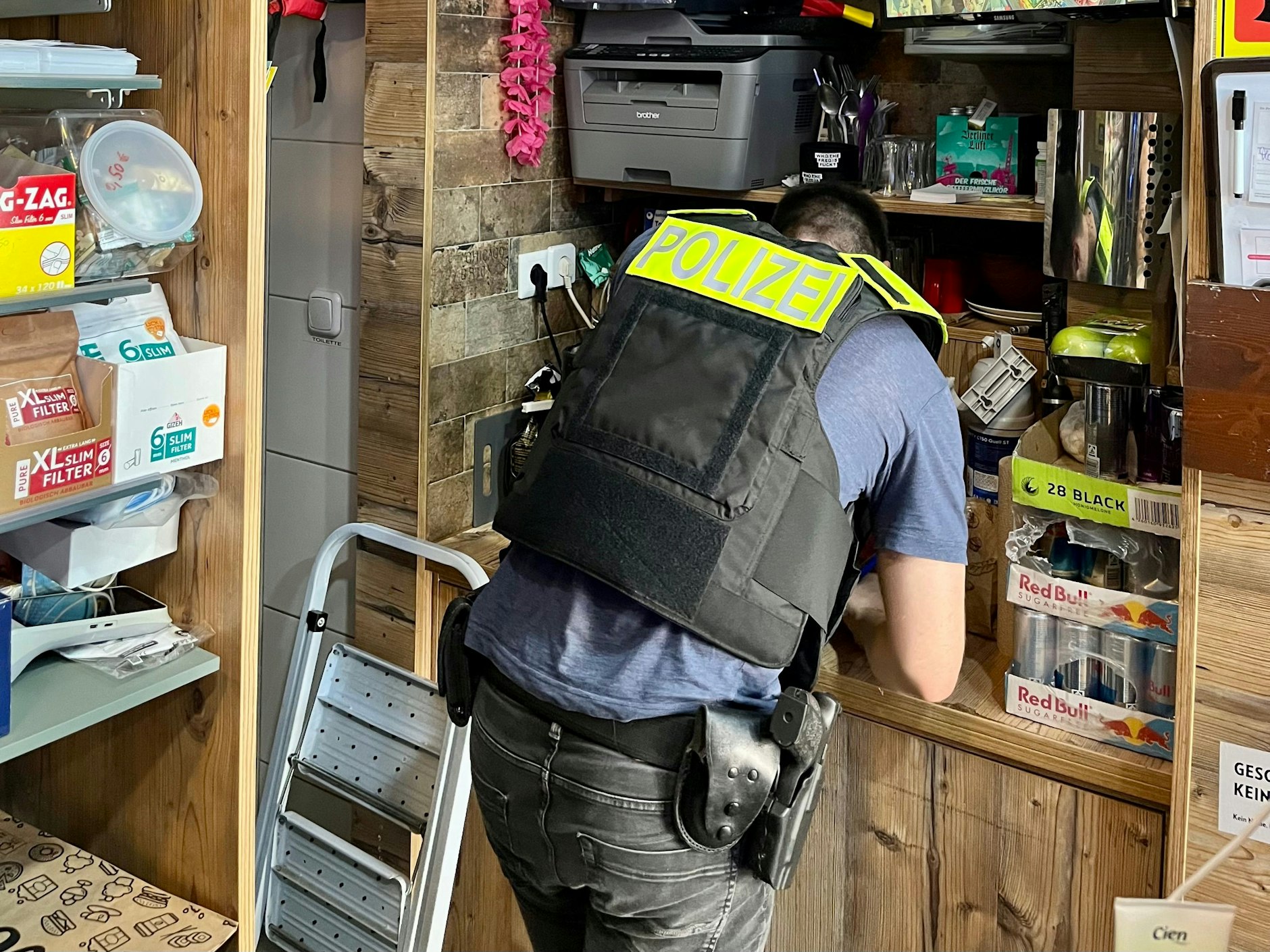 Hier sichert ein Polizist die Aufnahmen der Überwachungskamera eines Spätis in der Nähe des Tatorts.