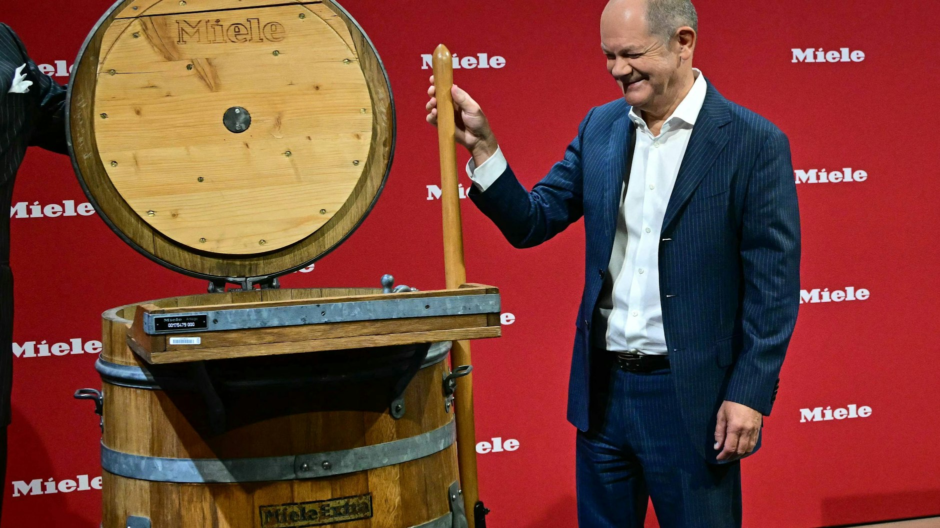 Auch dafür muss er herhalten: Bundeswäschemeister Olaf Scholz an einer alten Holzbottich-Waschmaschine von Miele. 