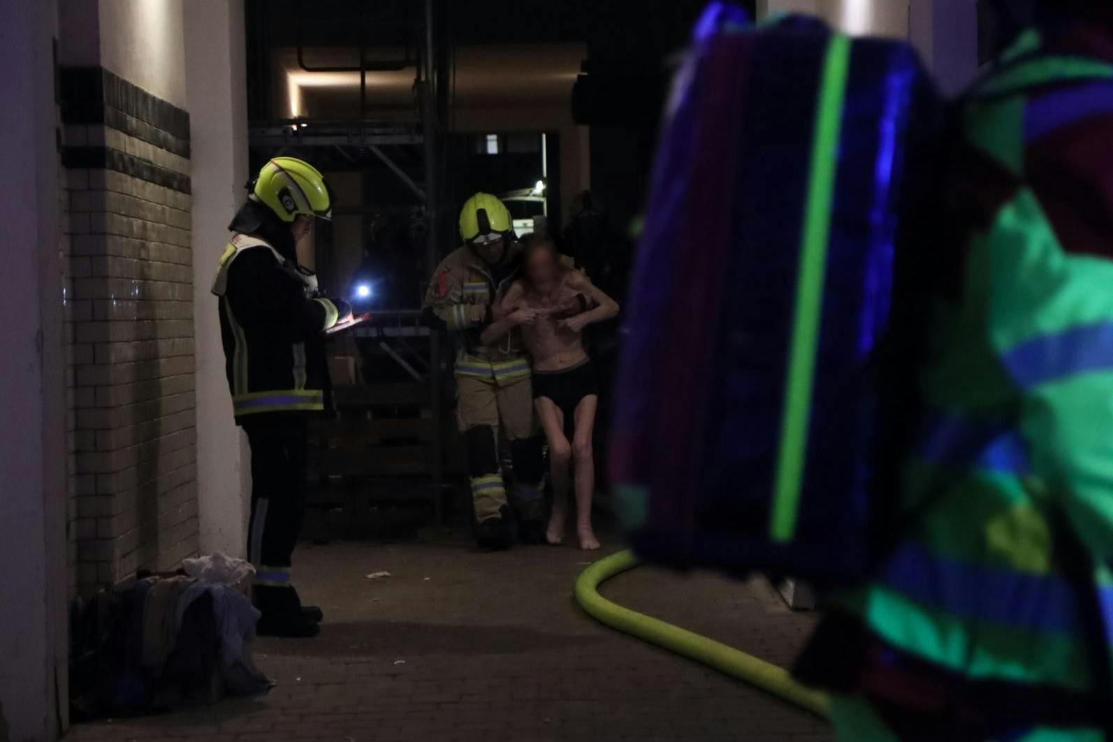 Feuerwehrleute retten einen Mann aus der Brandwohnung in der Flughafenstraße.