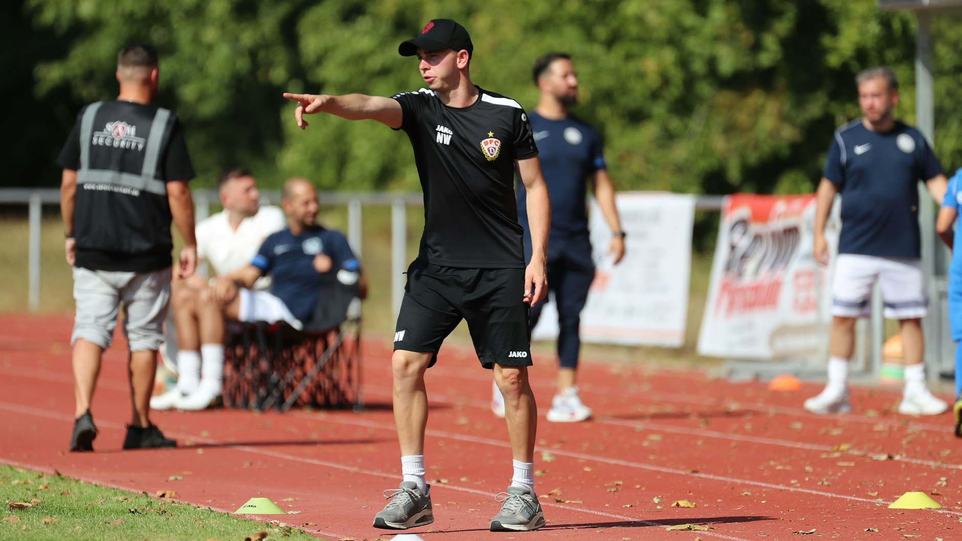 Nils Weiler spielt an der Seitenlinie voll mit. In kurzer Hose und mit Basecap gibt der BFC-Trainer seine Anweisungen.