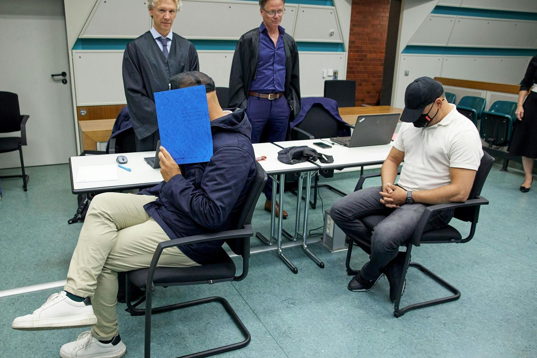 Die beiden angeklagten Polizisten Bülent L. (48, vorne li.) und Mehmet A (45, re.) mit ihren Anwälten.