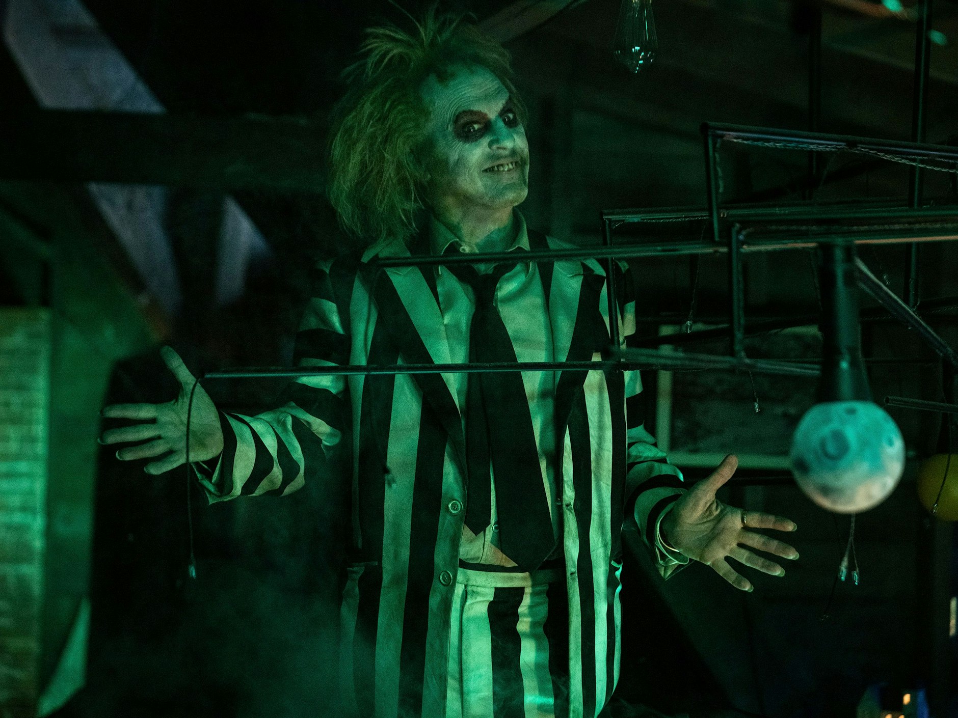 Michael Keaton spielt Beetlejuice, den bösen Geist mit den grünen Haaren und schwarz-weißen Streifenanzug.