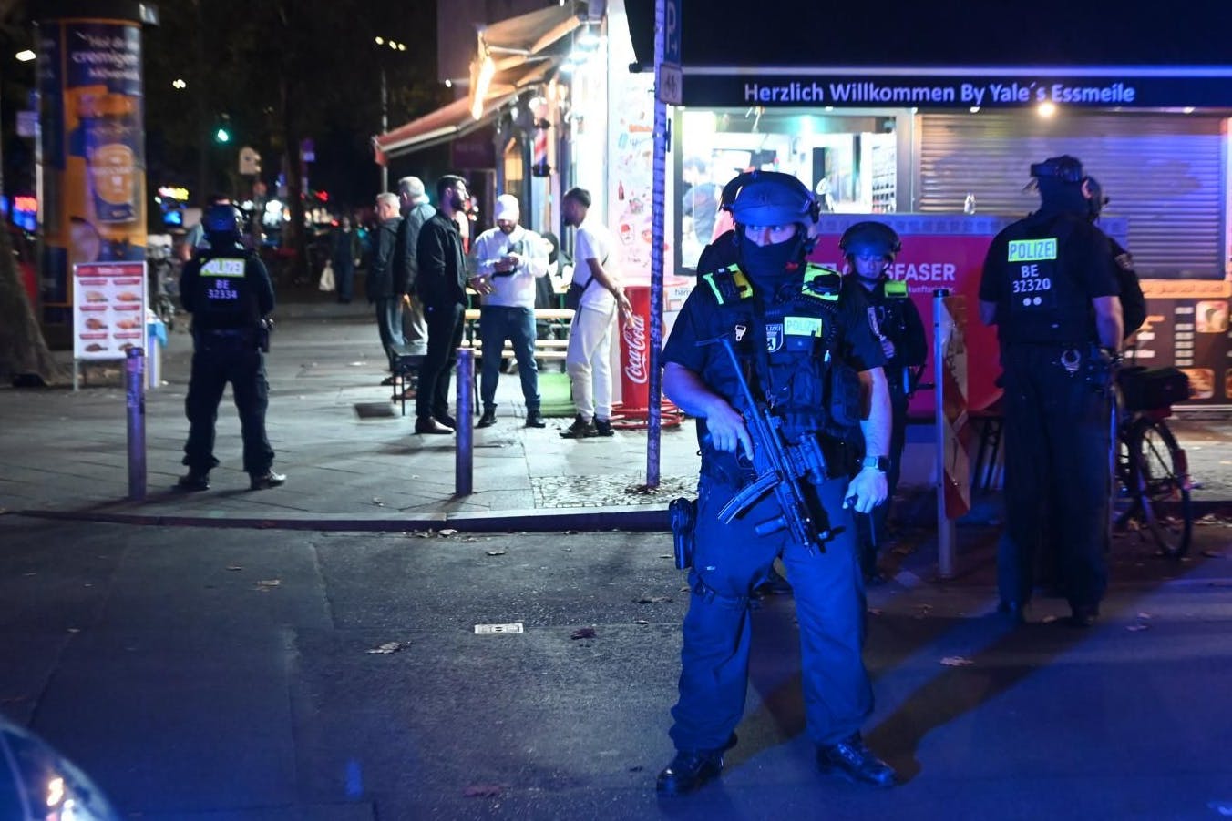 Schwerbewaffnete Polizeieinsatzkräfte sichern die Gegend um den Tatort.