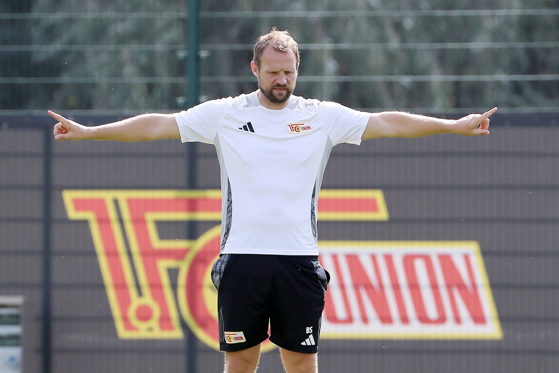 Trainer Bo Svensson gibt mit ausgestreckten Armen die Übung vor.