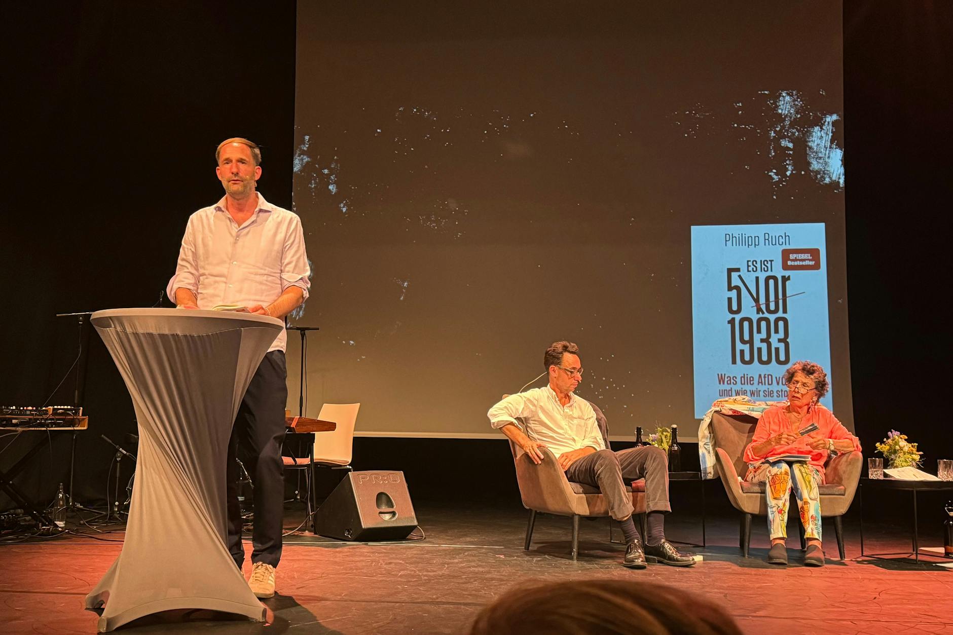 Philipp Ruch (l.) bei der Buchpräsentation im Pfefferberg-Theater, im Hintergrund die Publizisten Georg Diez und Lea Rosh. 