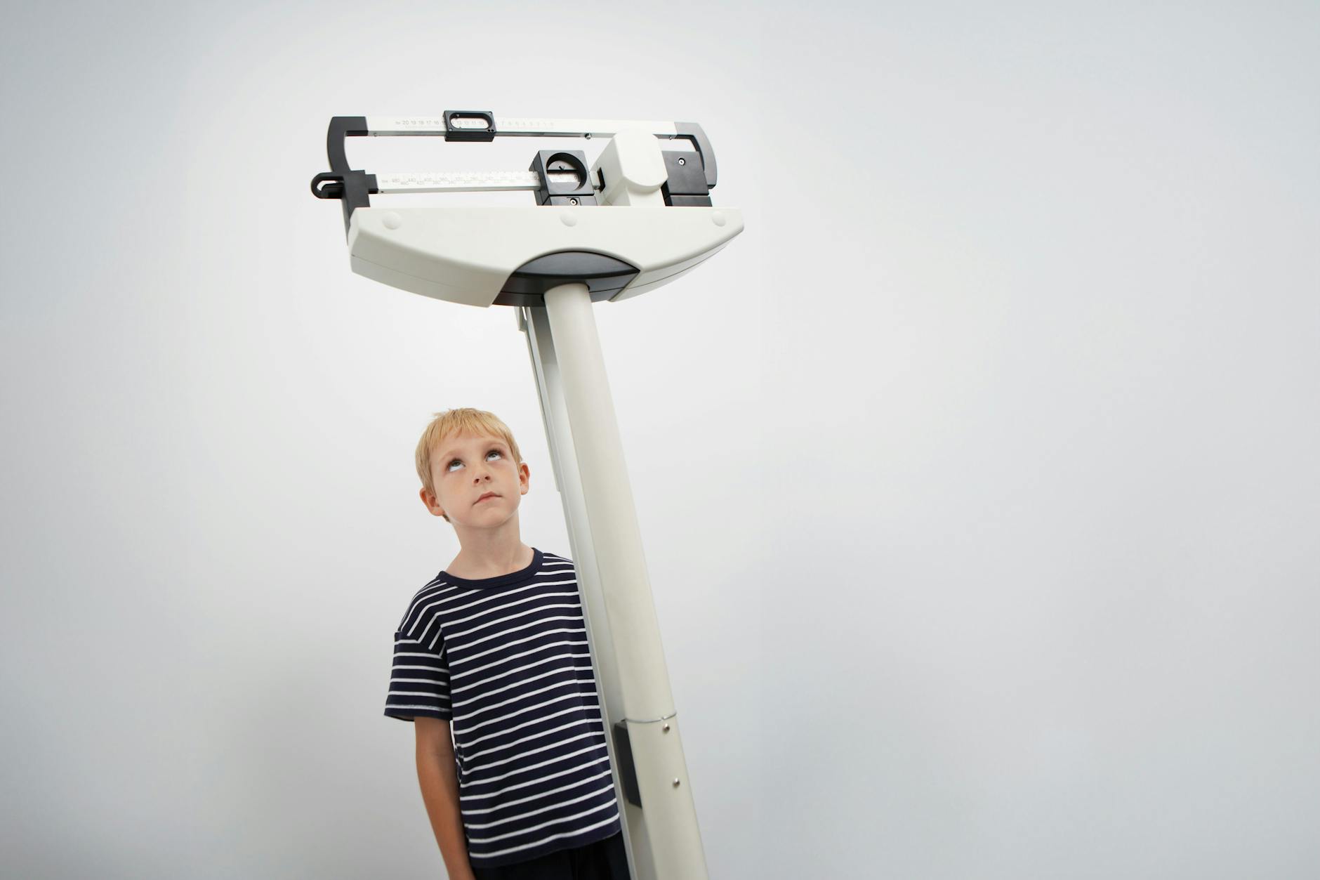 Ein Junge betrachtet eine Personenwaage.