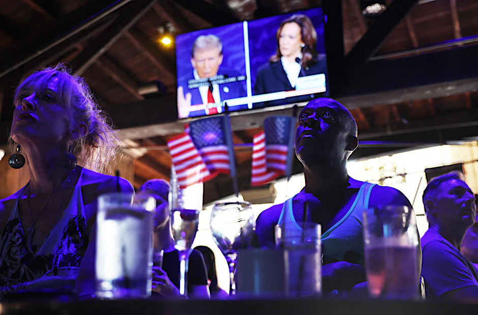 Menschen beobachten die Präsidentschaftsdebatte zwischen Donald Trump und Kamala Harris.