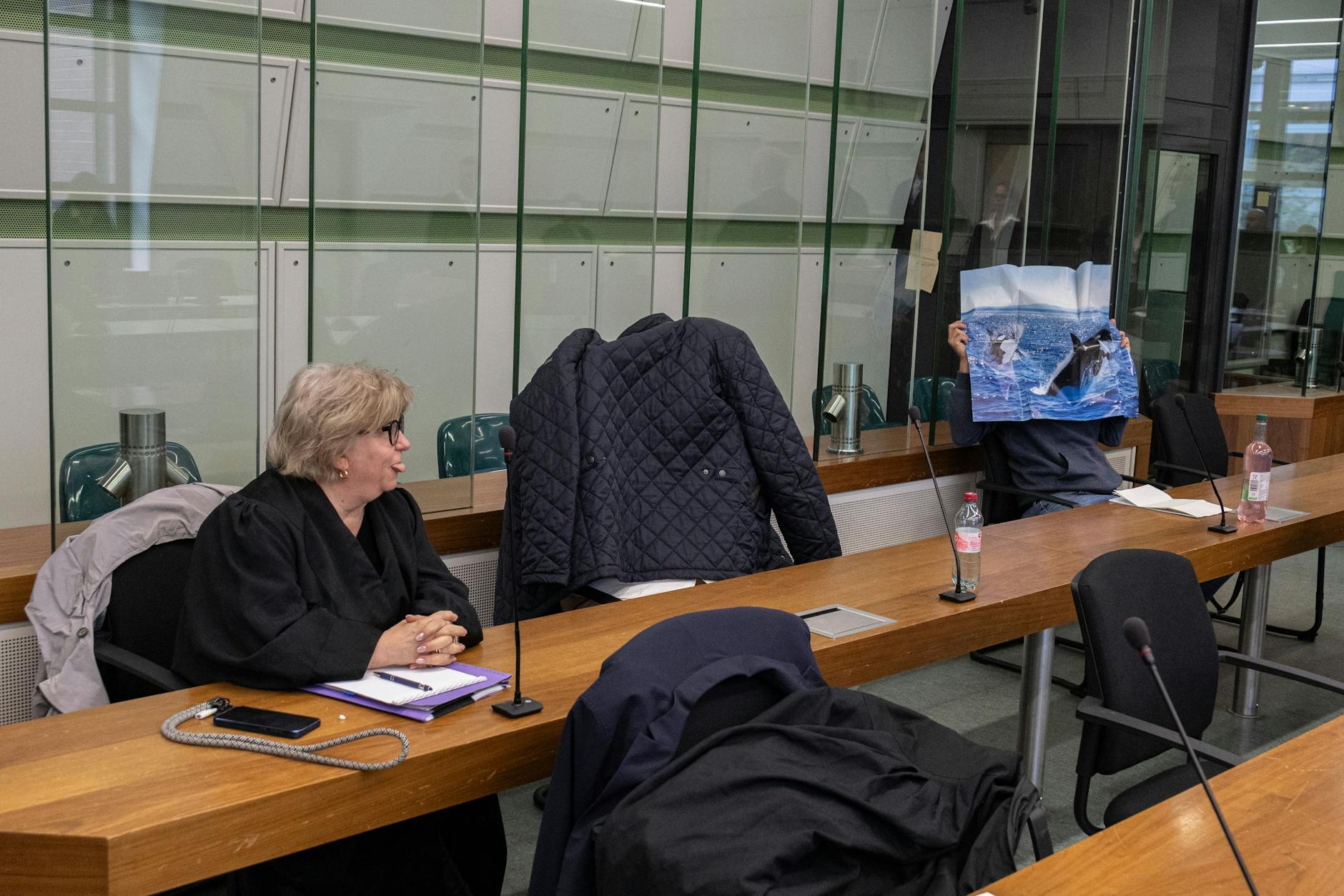 Die Berliner Neonazis vor Gericht: Sebastian T. (mit Poster) und Tilo P. (mit Jacke überm Kopf).