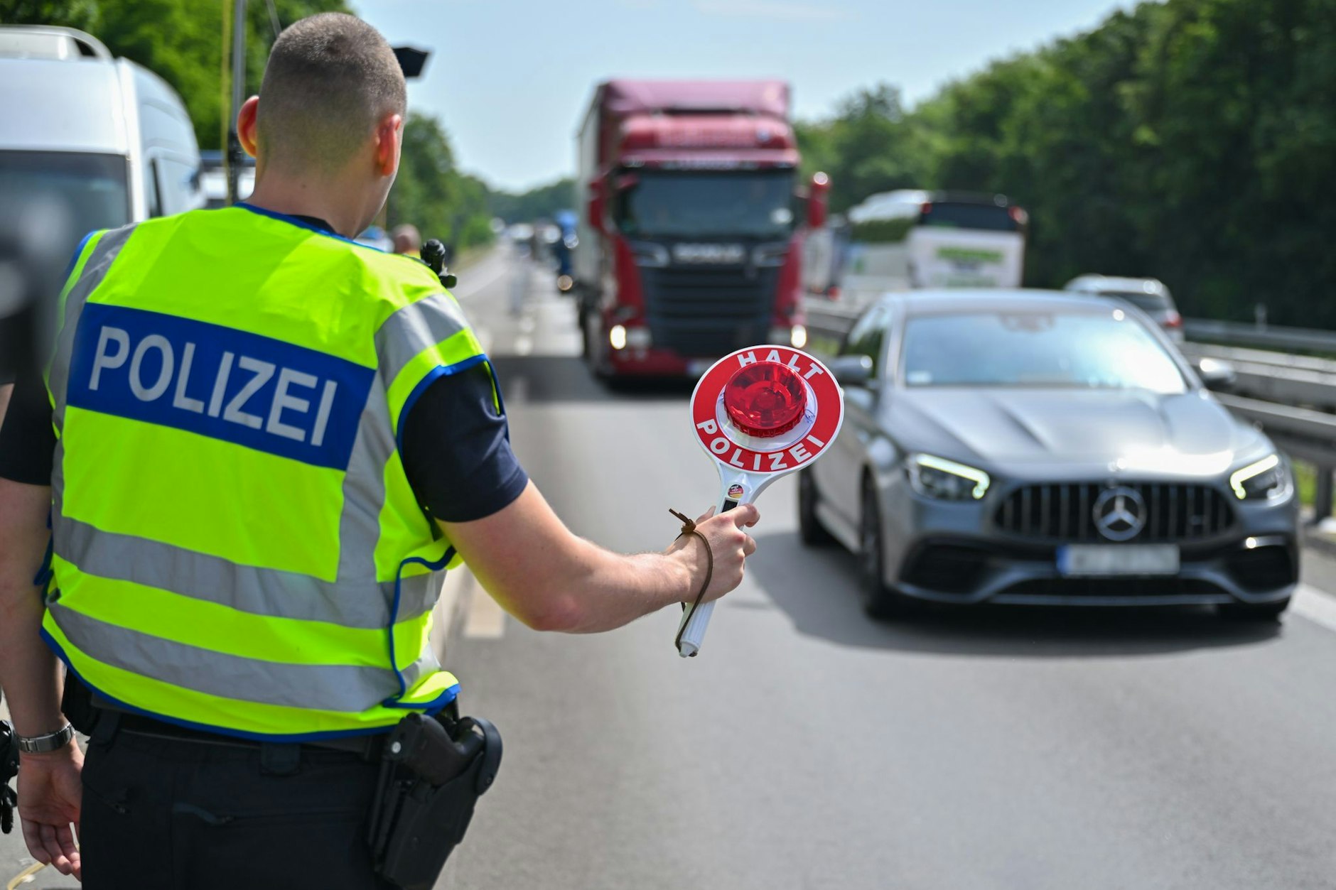 Ein Beamter der Bundespolizei steht auf der Autobahn A12 nahe dem deutsch-polnischen Grenzübergang und stoppt ein Auto.